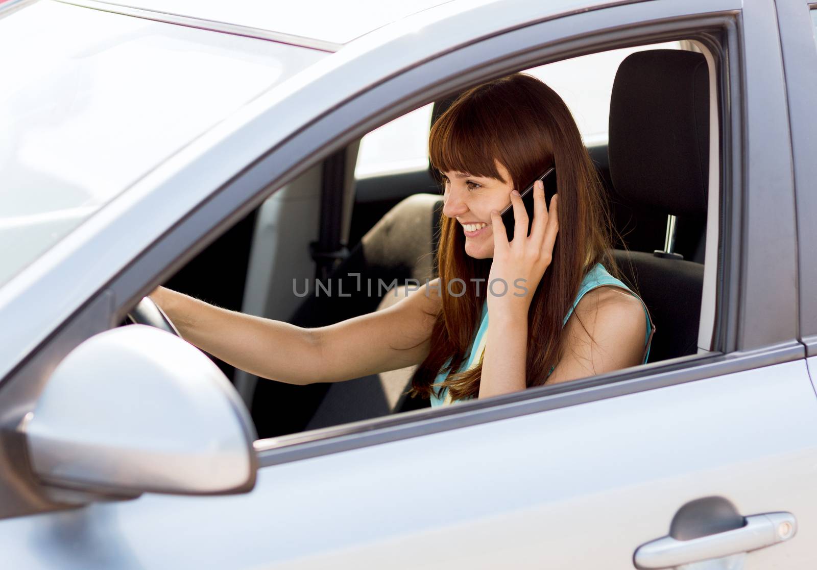 woman using phone while driving the car by dolgachov