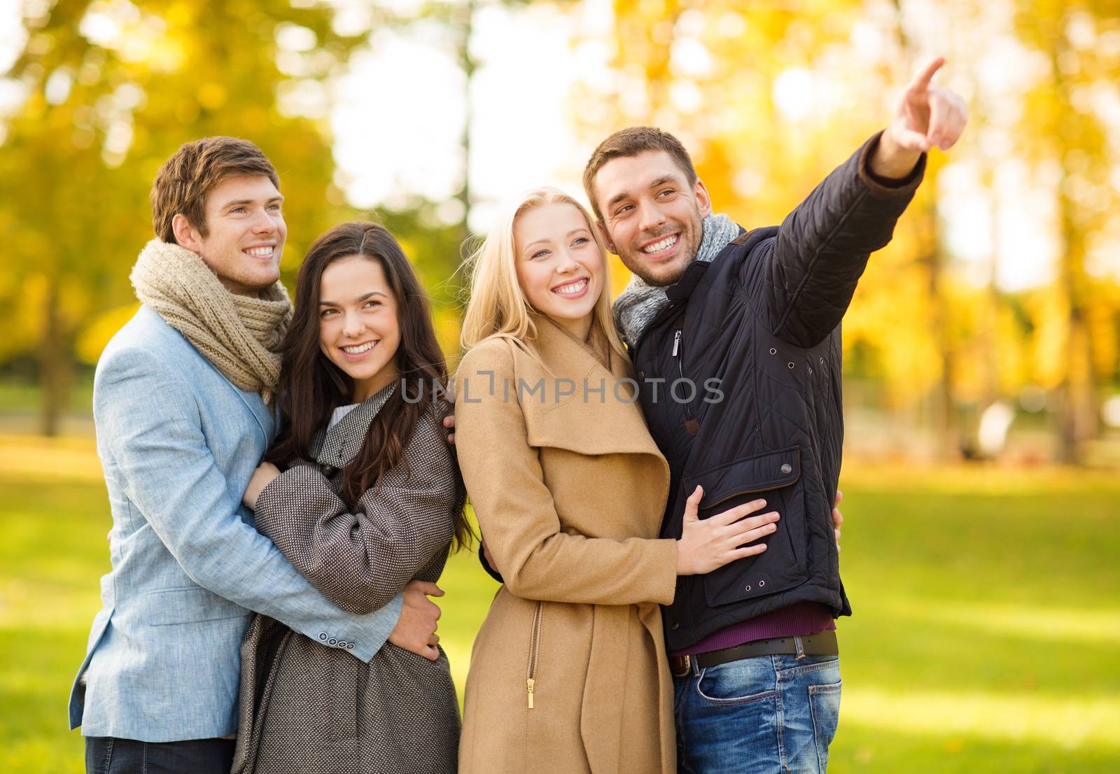 group of friends having fun in autumn park by dolgachov