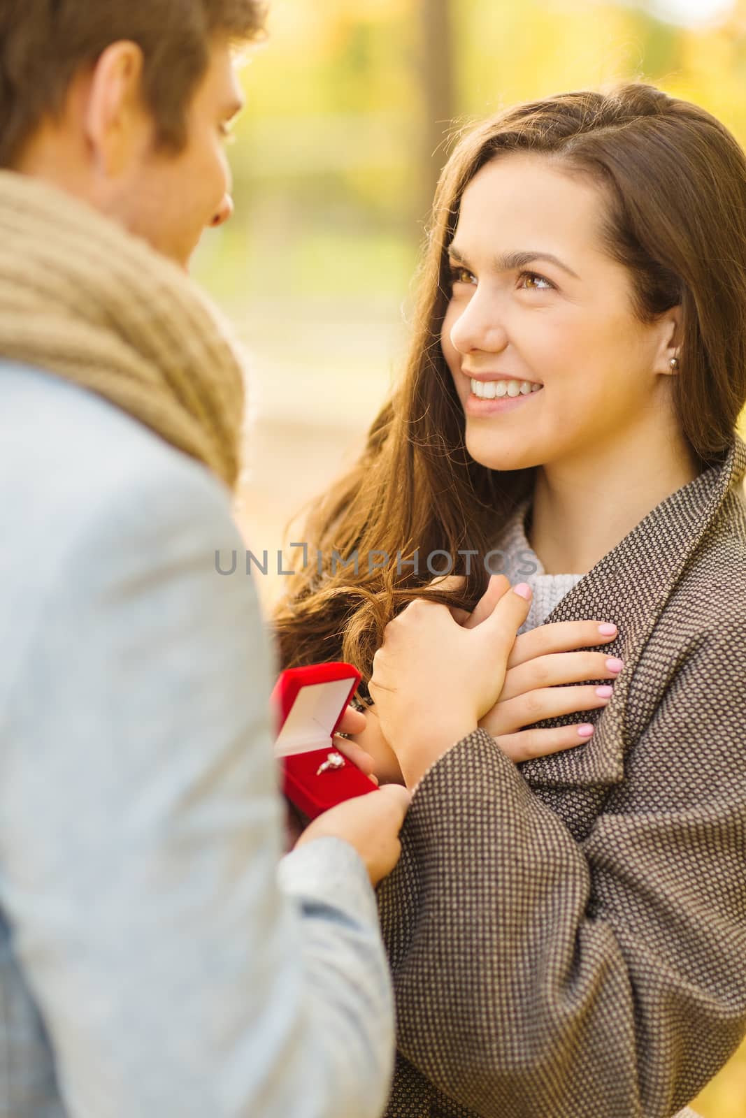 holidays, love, couple, relationship and dating concept - romantic man proposing to a woman in the autumn park