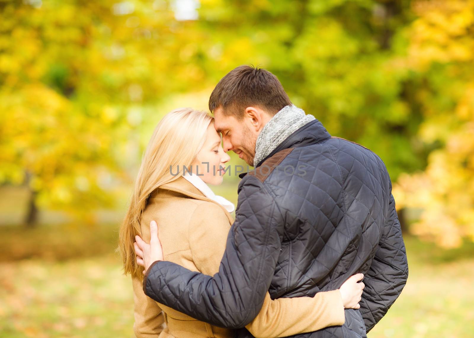 romantic couple kissing in the autumn park by dolgachov