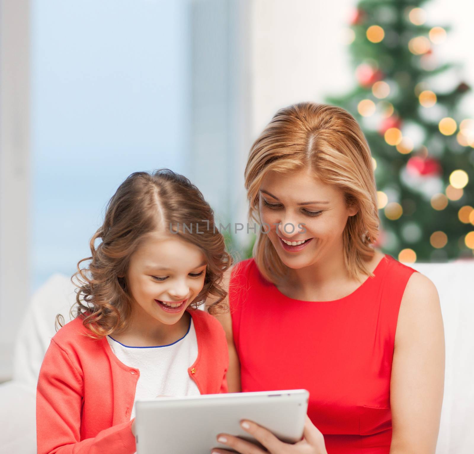 christmas, x-mas, winter, happiness, modern technology concept - mother and daughter with tablet pc