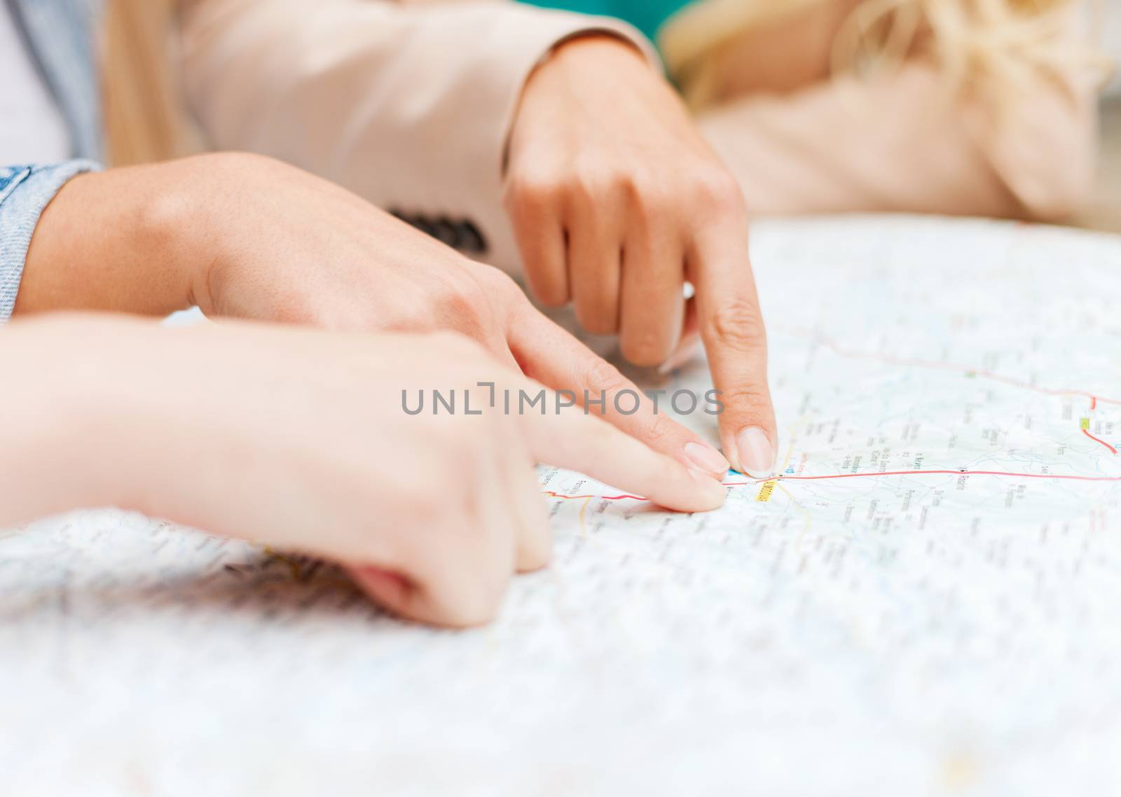 holidays and tourism concept - women with tourist map in the city