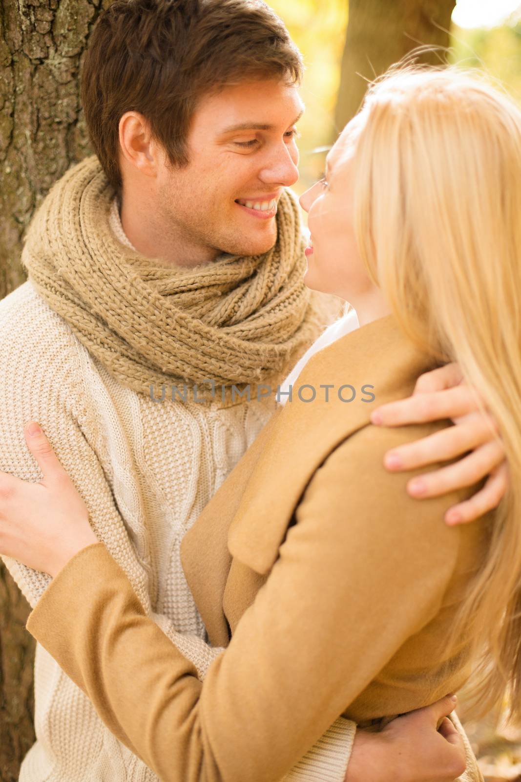 holidays, love, travel, tourism, relationship and dating concept - romantic couple kissing in the autumn park