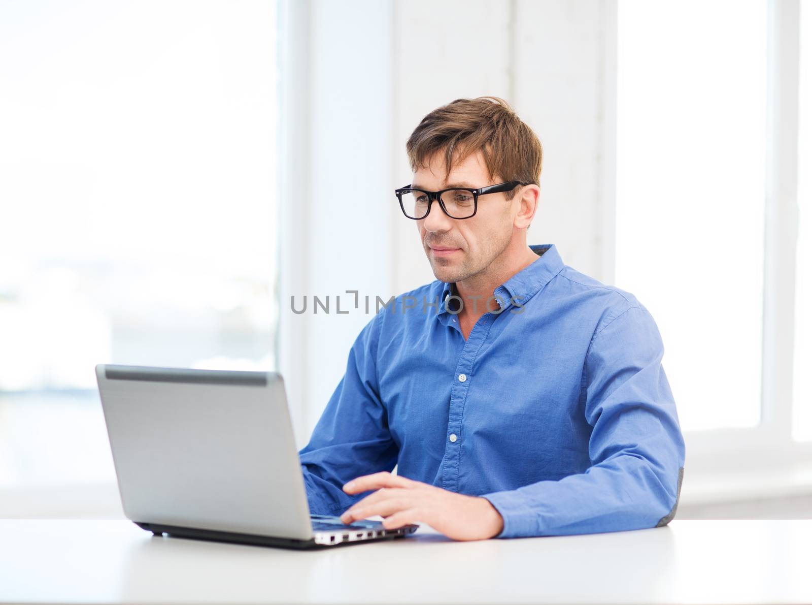 man working with laptop at home by dolgachov