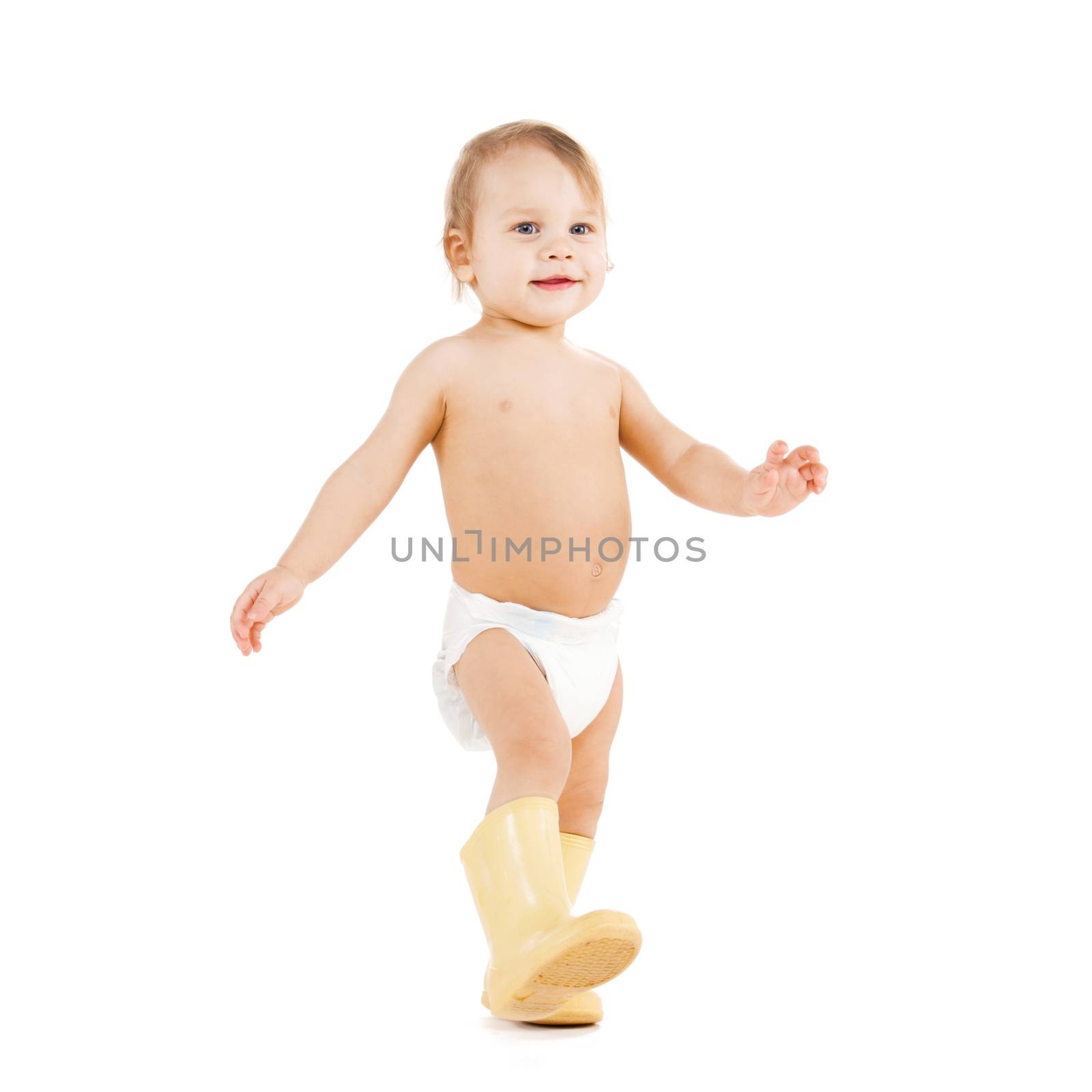 childhood and toys concept - cute little boy walking in big rubber boots