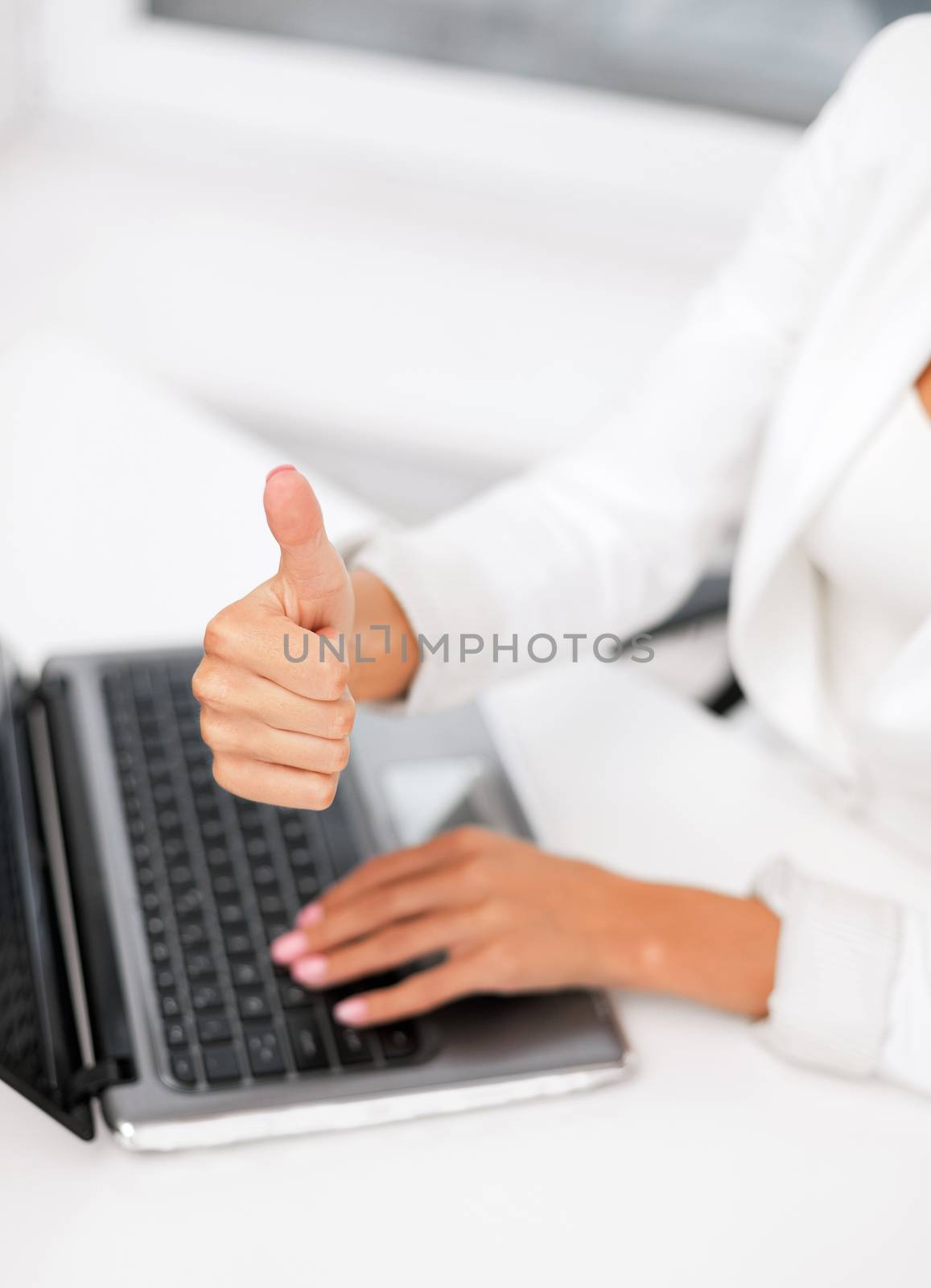 businesswoman with laptop showing thumbs up by dolgachov