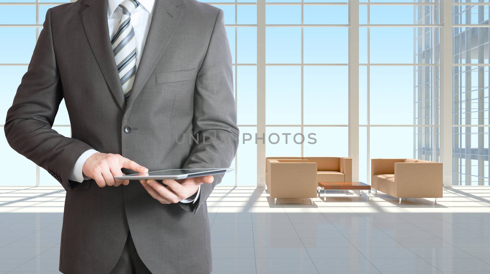 Businessman holding tablet pc. Large window in office building as background