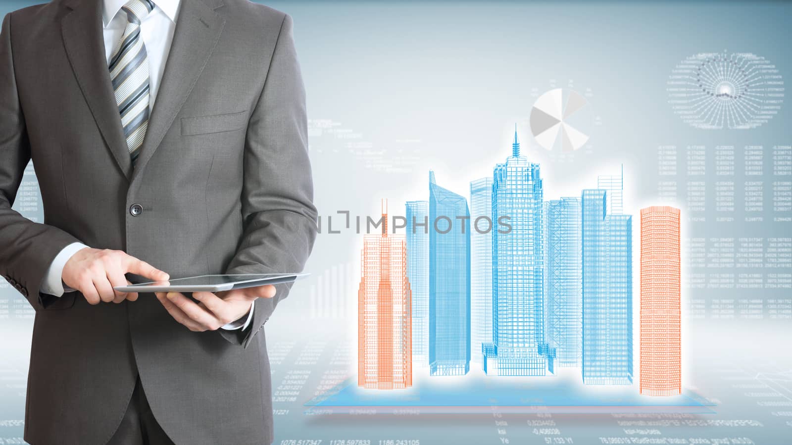 Businessman holding tablet pc. On background of the high-tech wire frame skyscrapers and graphs