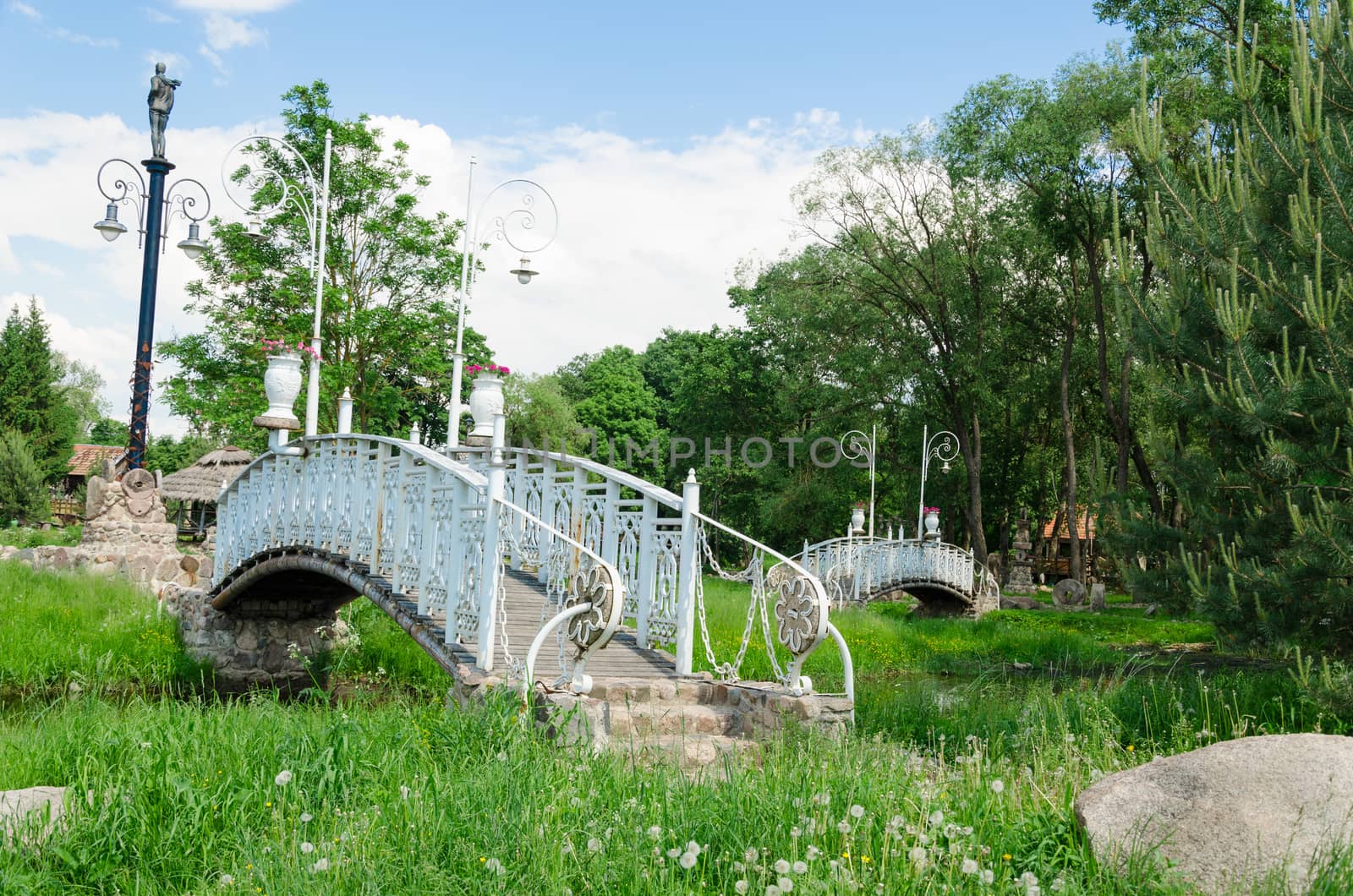 antique white bridge with spectacular park lights by sauletas