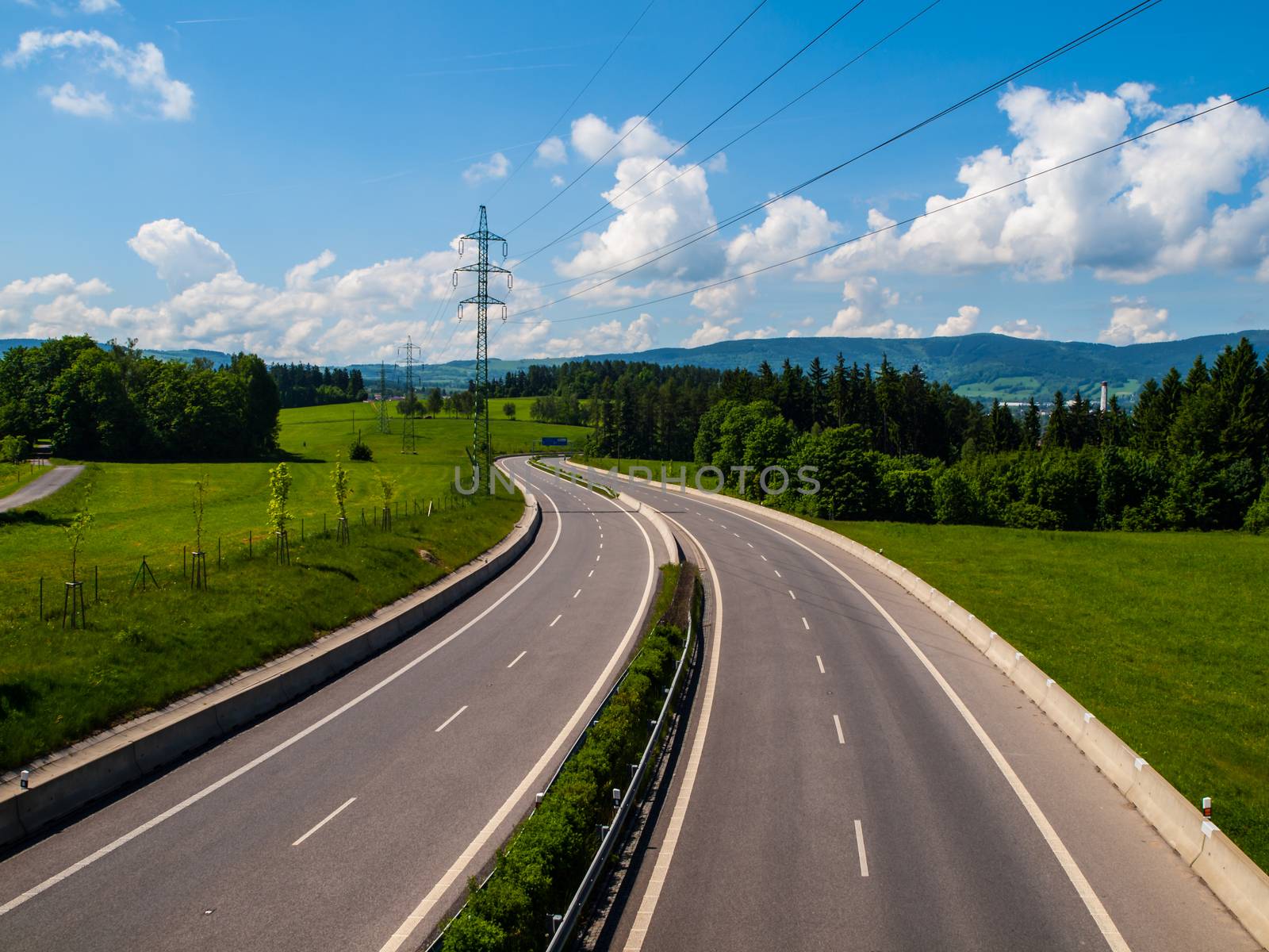 Two line wide highway with curve in sunny day