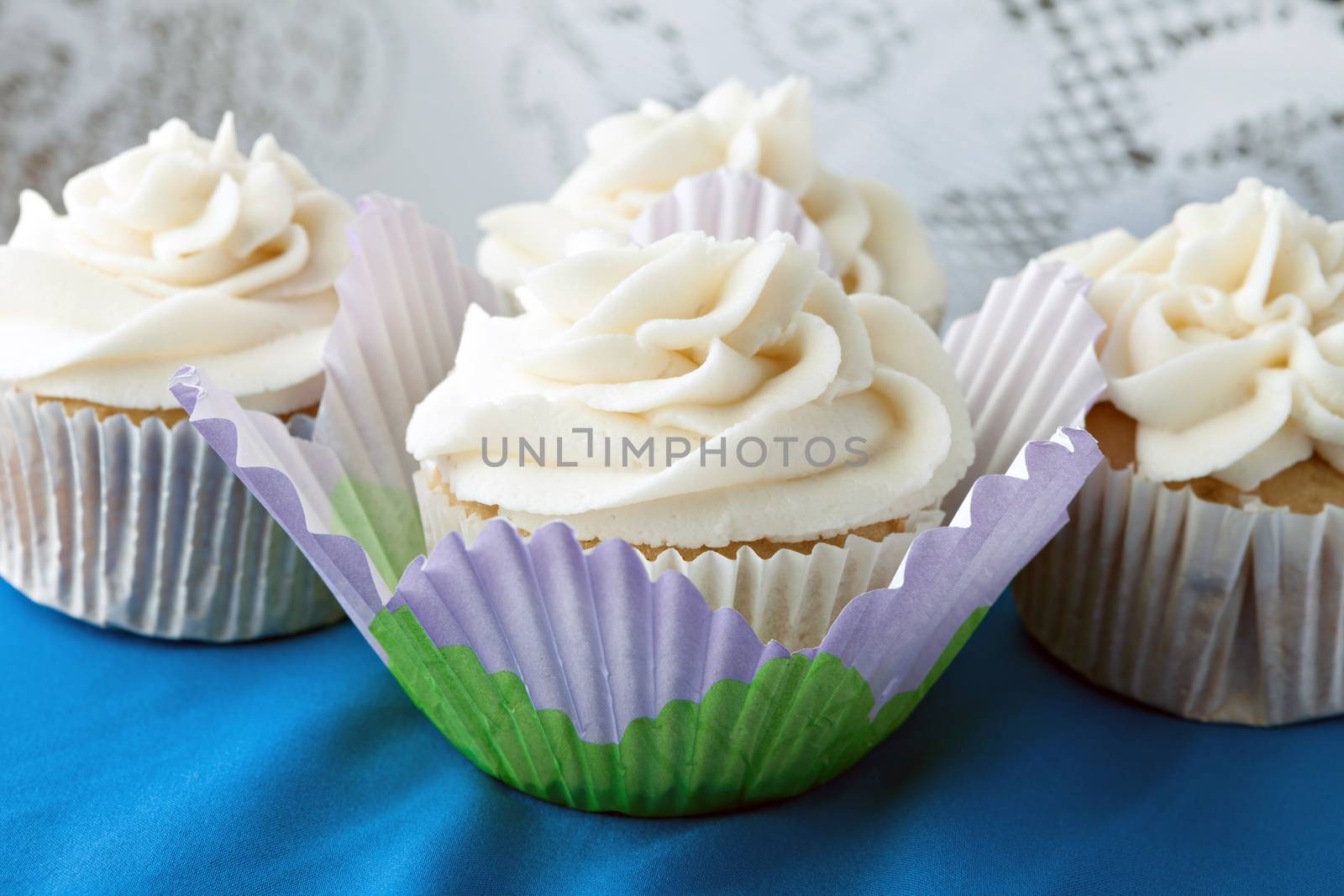 Close up of some decadent gourmet cupcakes with vanilla frosting. 