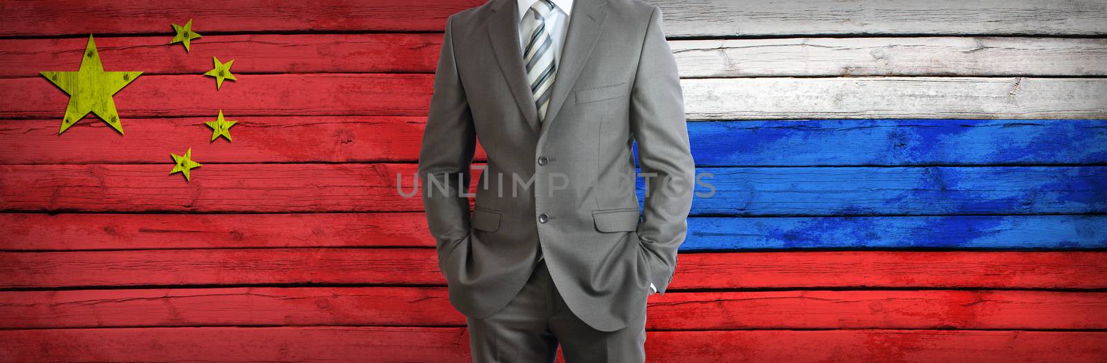 Businessman in a suit. China and Russian flags as background. Concept of business