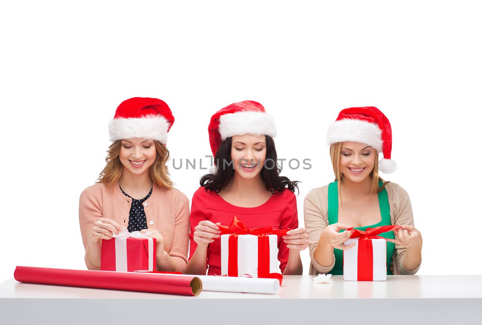 christmas, x-mas, winter, happiness concept - three smiling women in santa helper hats with gift boxes