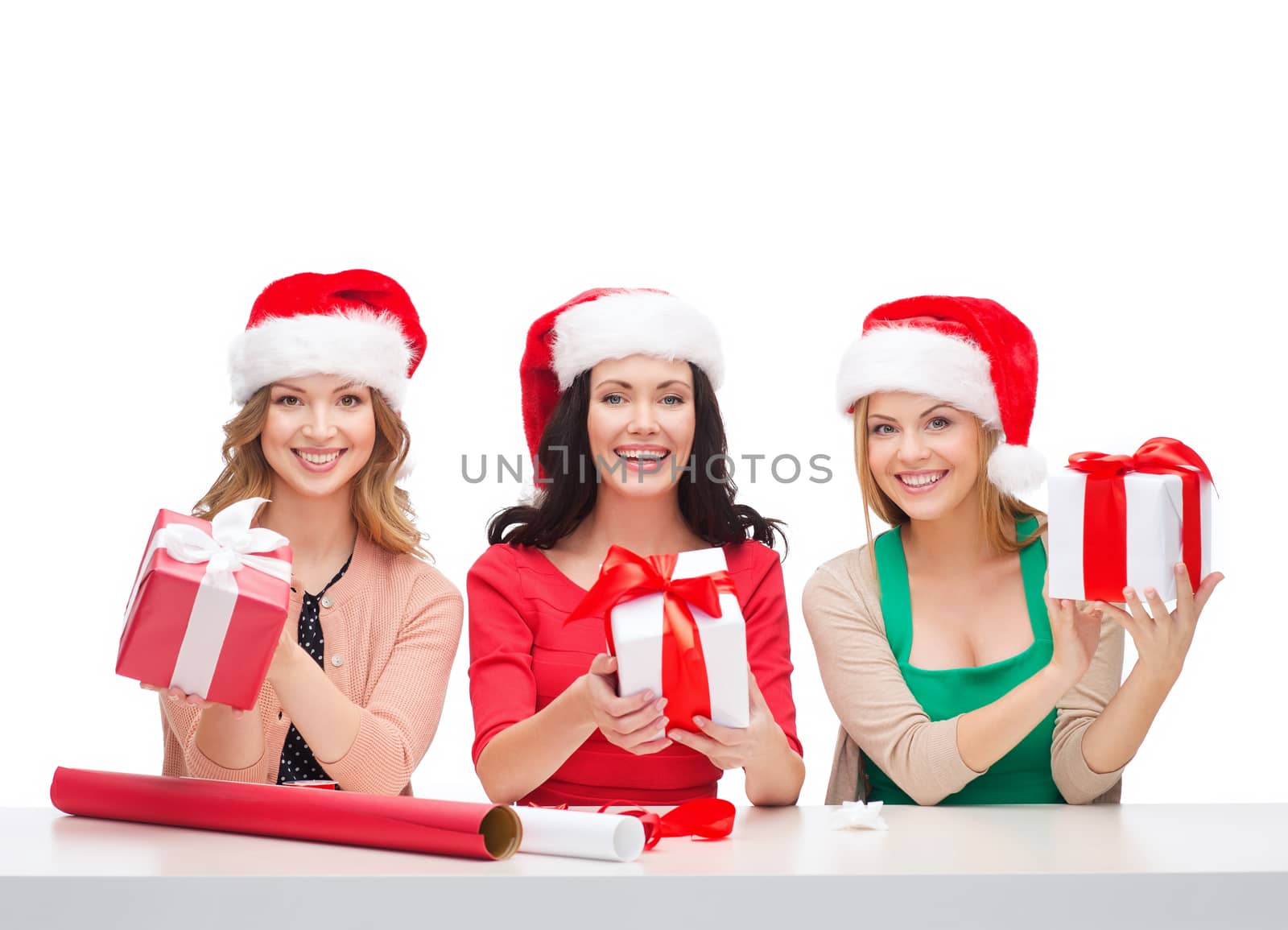 christmas, x-mas, winter, happiness concept - three smiling women in santa helper hats with gift boxes