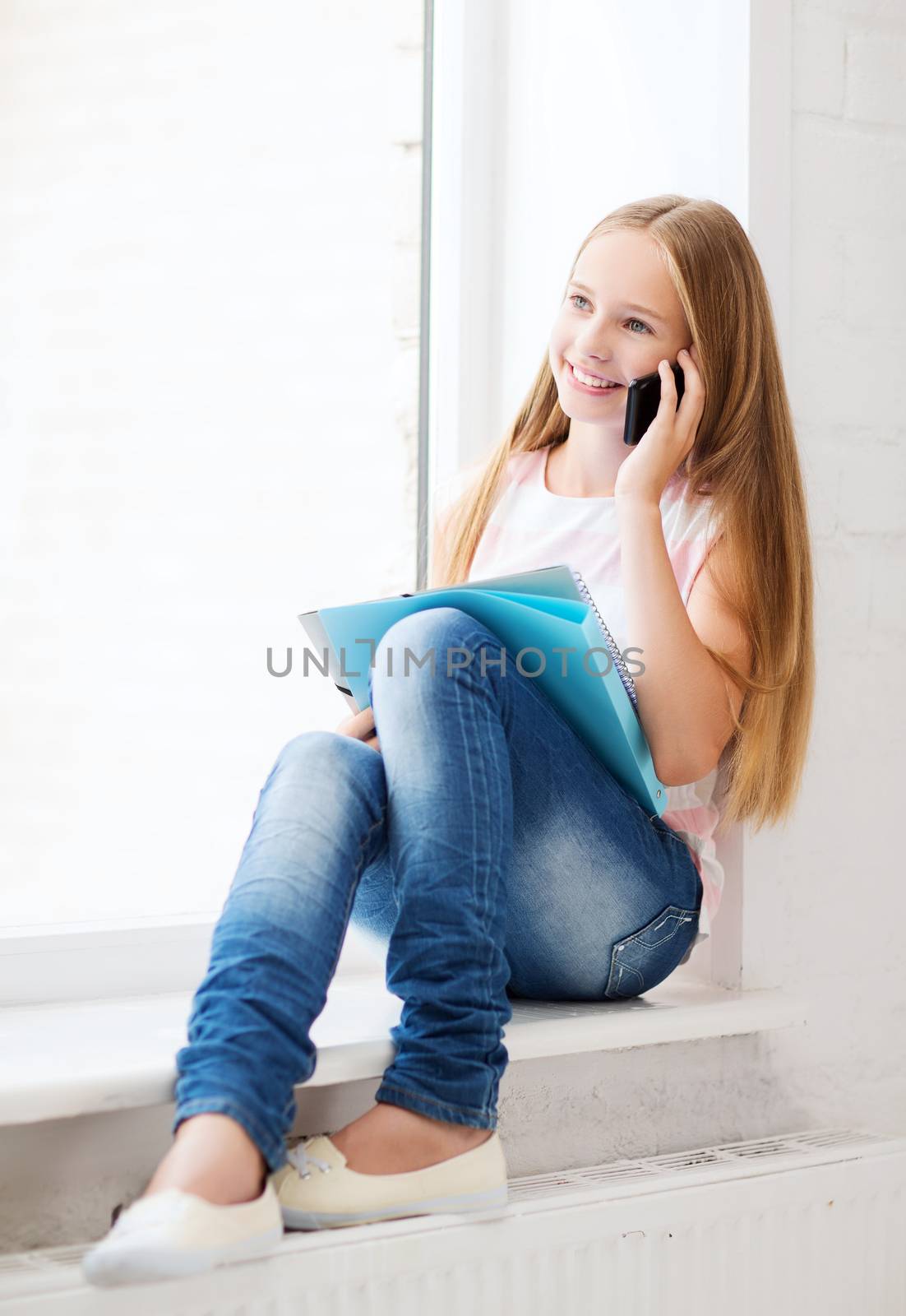 girl with smartphone at school by dolgachov