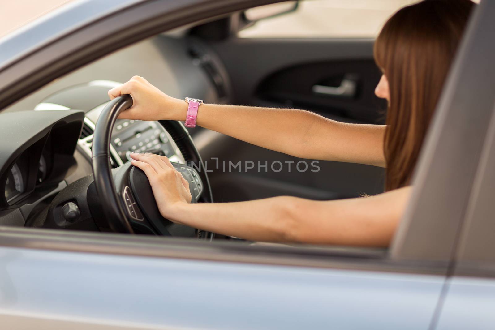 transportation and vehicle concept - woman driving a car with hand on horn button