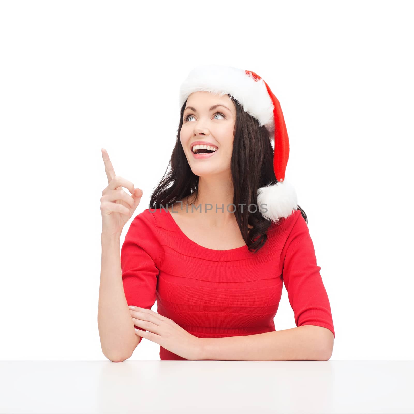 christmas, x-mas, winter, happiness concept - smiling woman in santa helper hat pointing to something