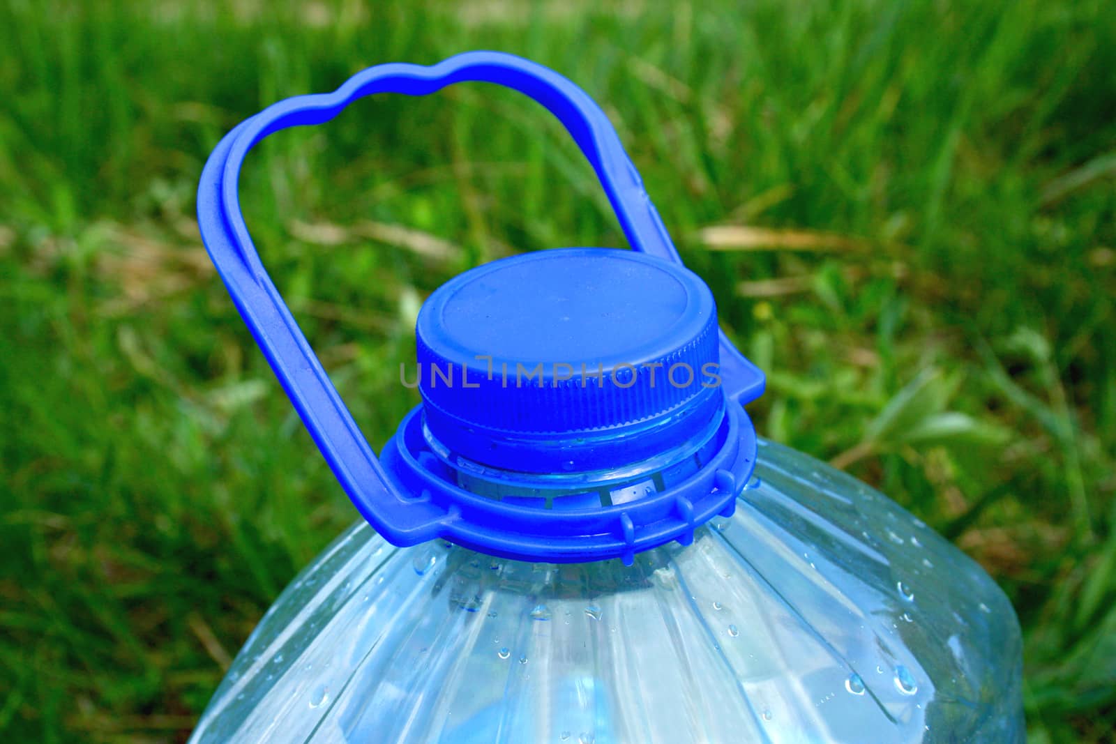 part of a large water bottle on the grass
