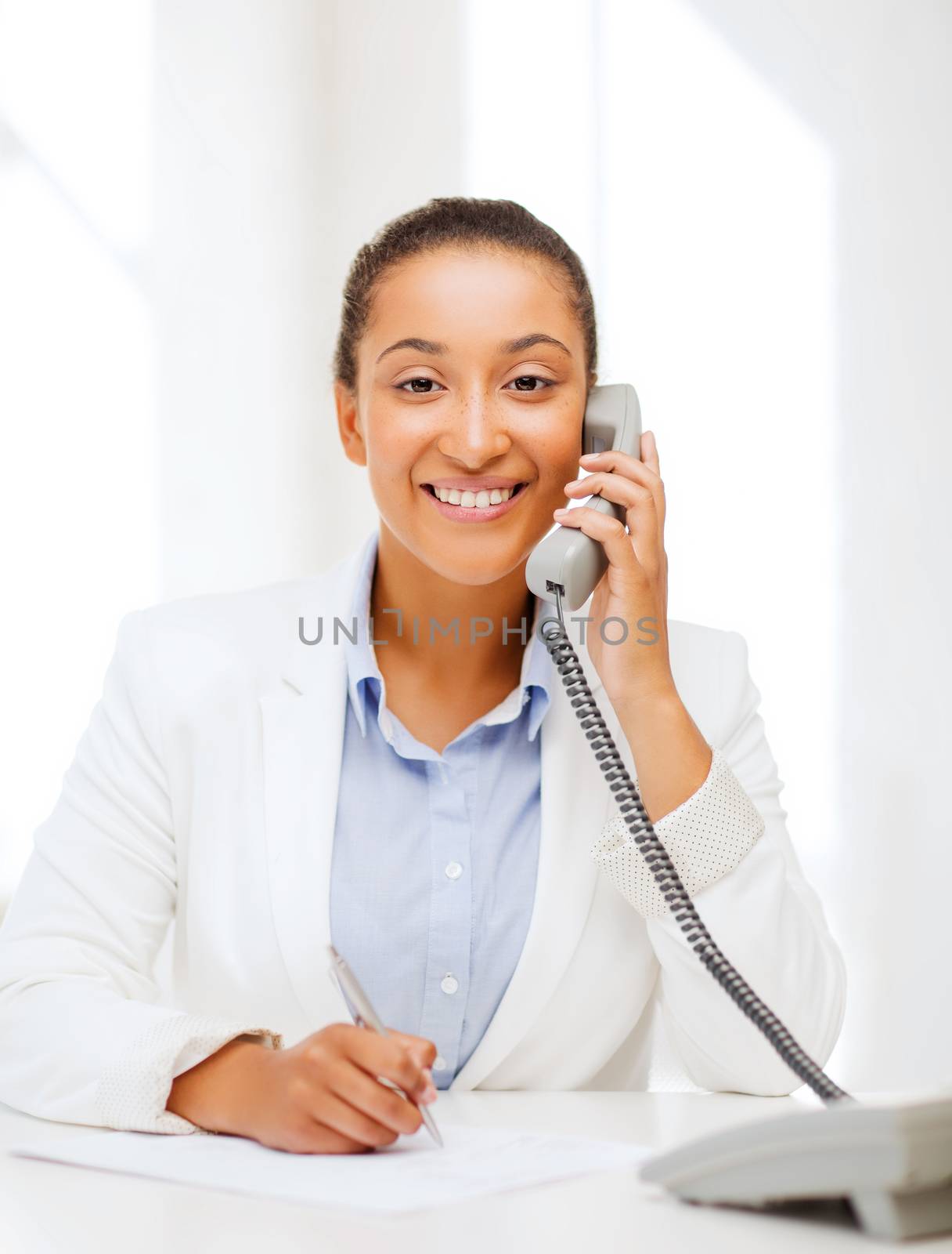 african businesswoman with phone in office by dolgachov