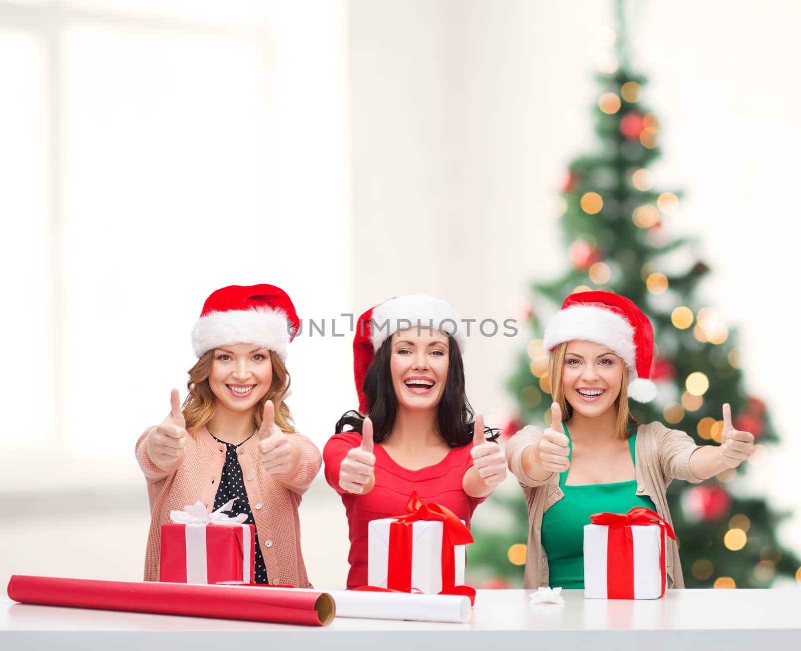 smiling women in santa helper hats with gift boxes by dolgachov