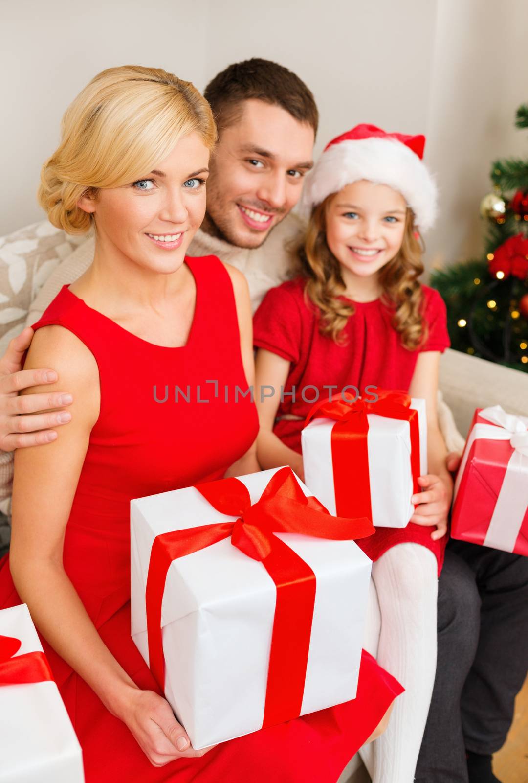 family, christmas, x-mas, winter, happiness and people concept - smiling family in santa helper hats with many gift boxes