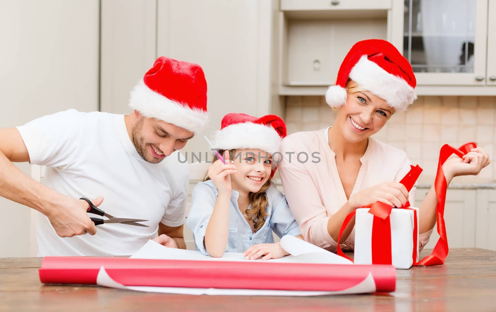 christmas, x-mas, winter,family, happiness and people concept - smiling family in santa helper hats with gift box