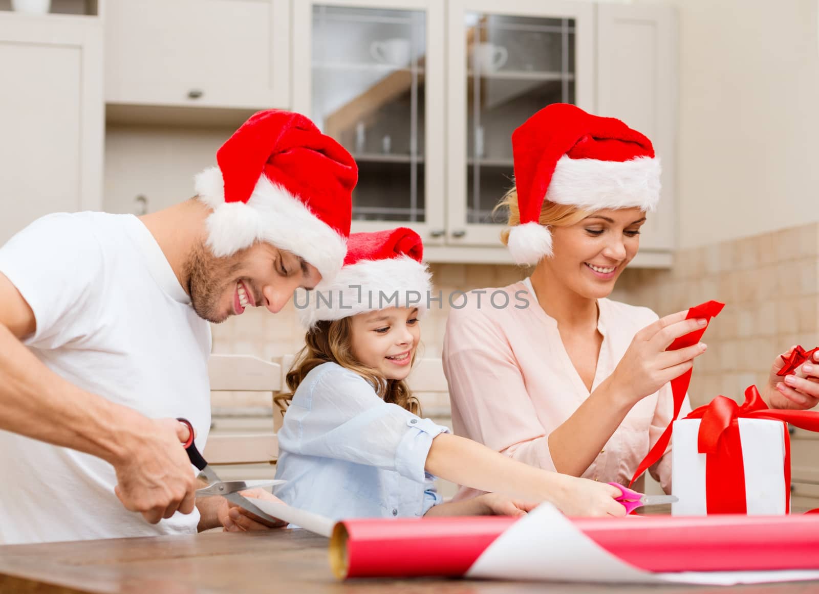 christmas, x-mas, winter,family, happiness and people concept - smiling family in santa helper hats with gift box