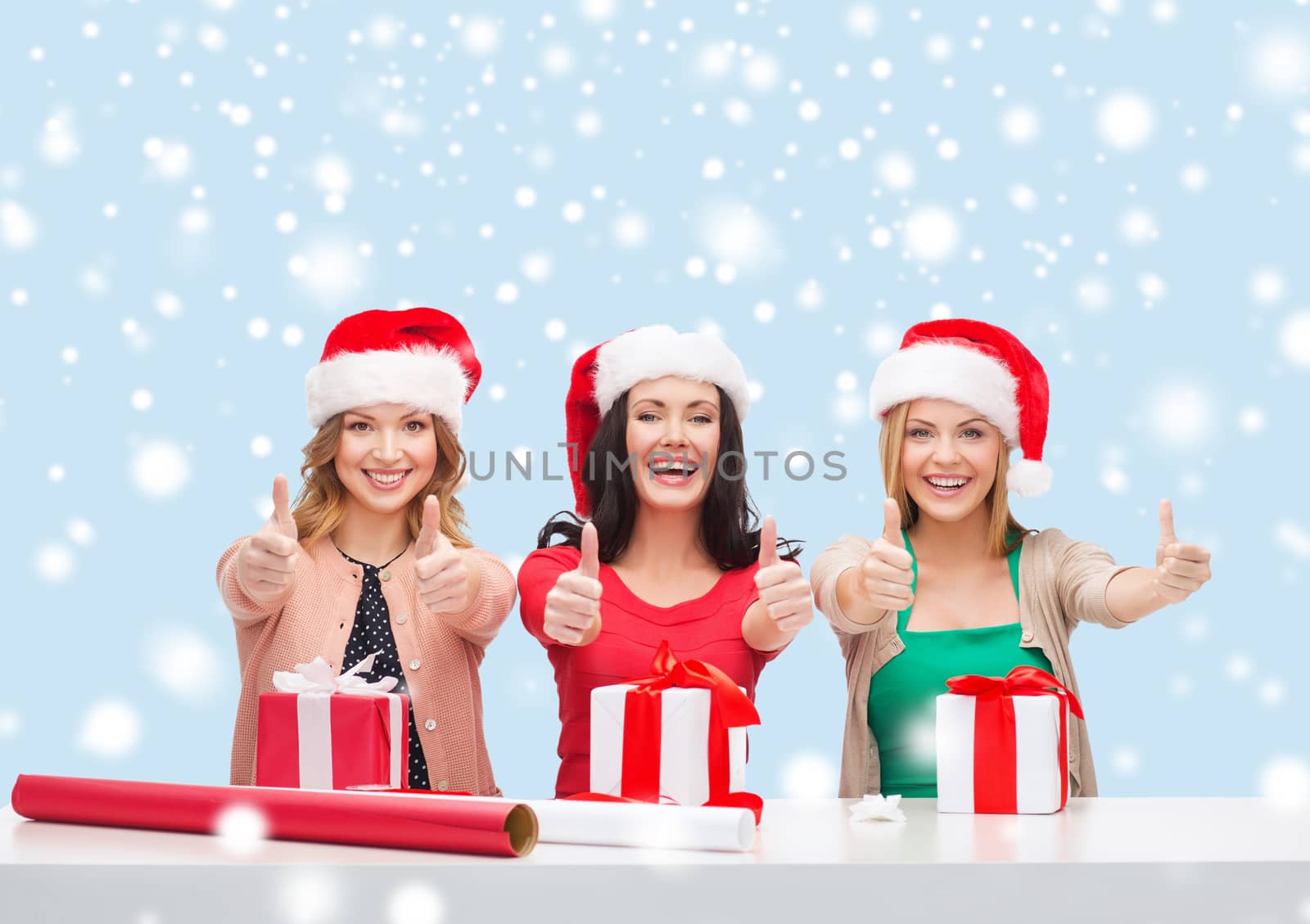 christmas, x-mas, winter, happiness concept - three smiling women in santa helper hats with gift boxes