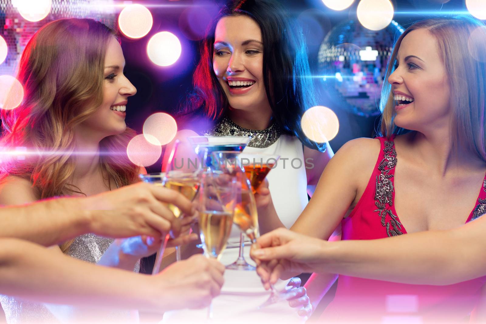 new year, celebration, friends, bachelorette party, birthday concept - three women in evening dresses with cocktails in club or bar