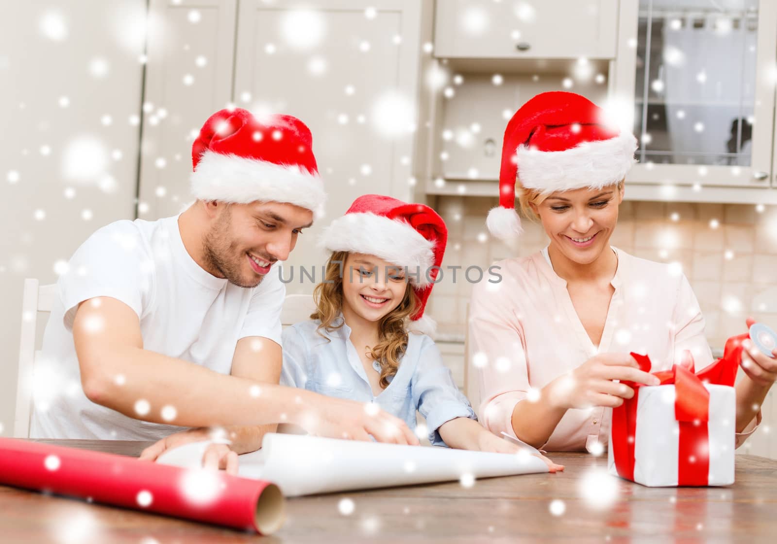 smiling family in santa helper hats with gift box by dolgachov