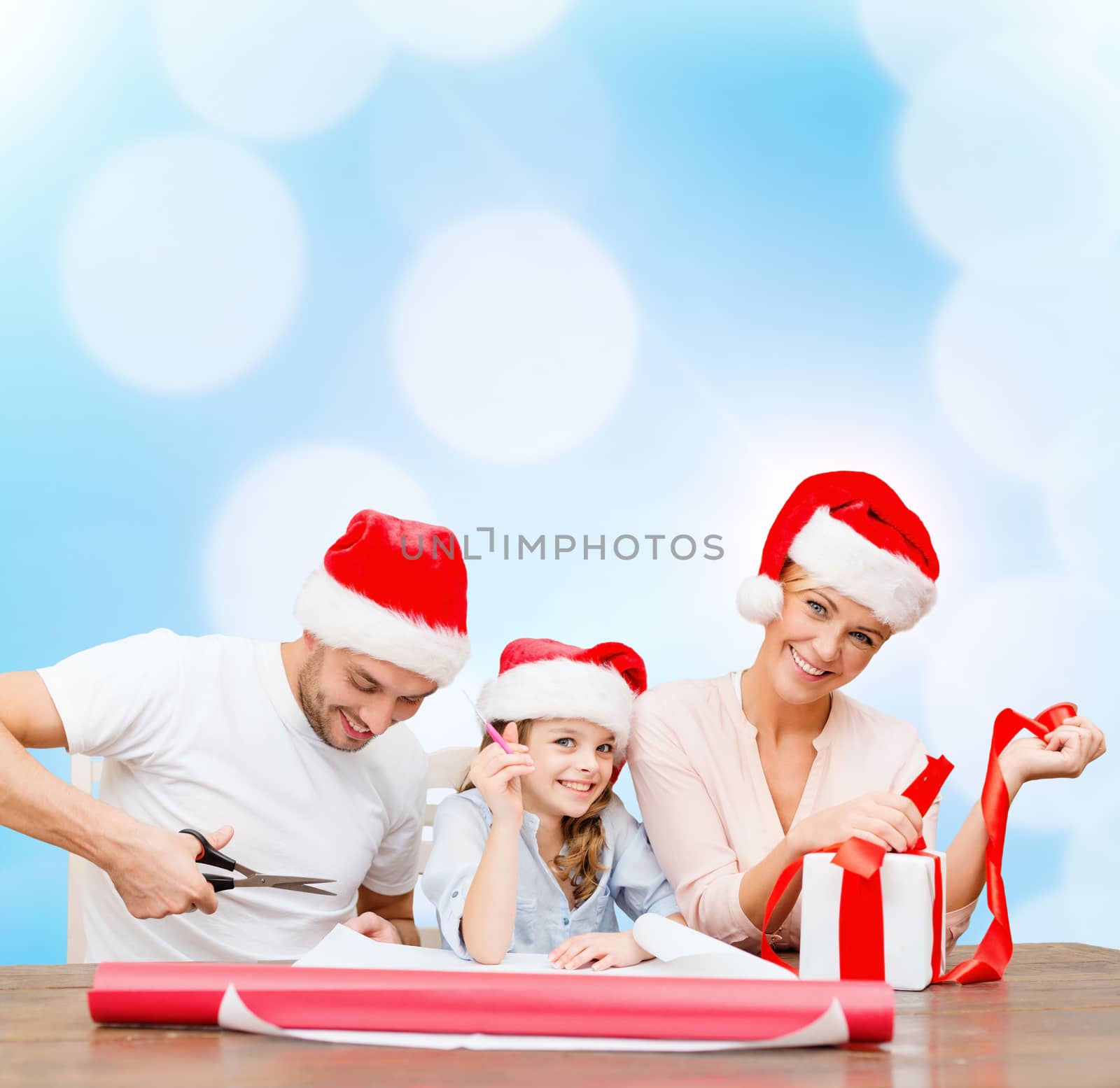 smiling family in santa helper hats with gift box by dolgachov