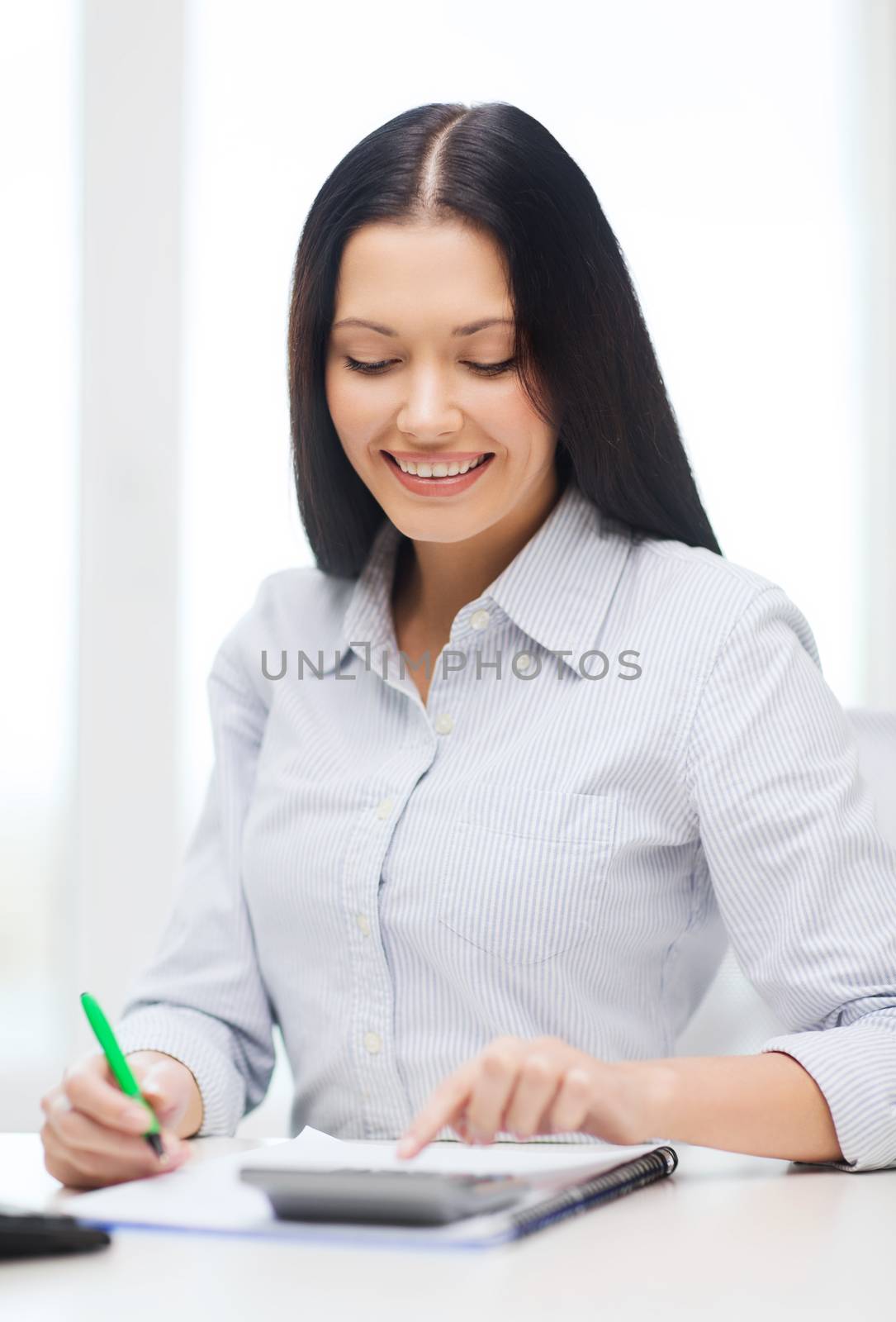 business, education and tax concept - smiling businesswoman or student working with calculator