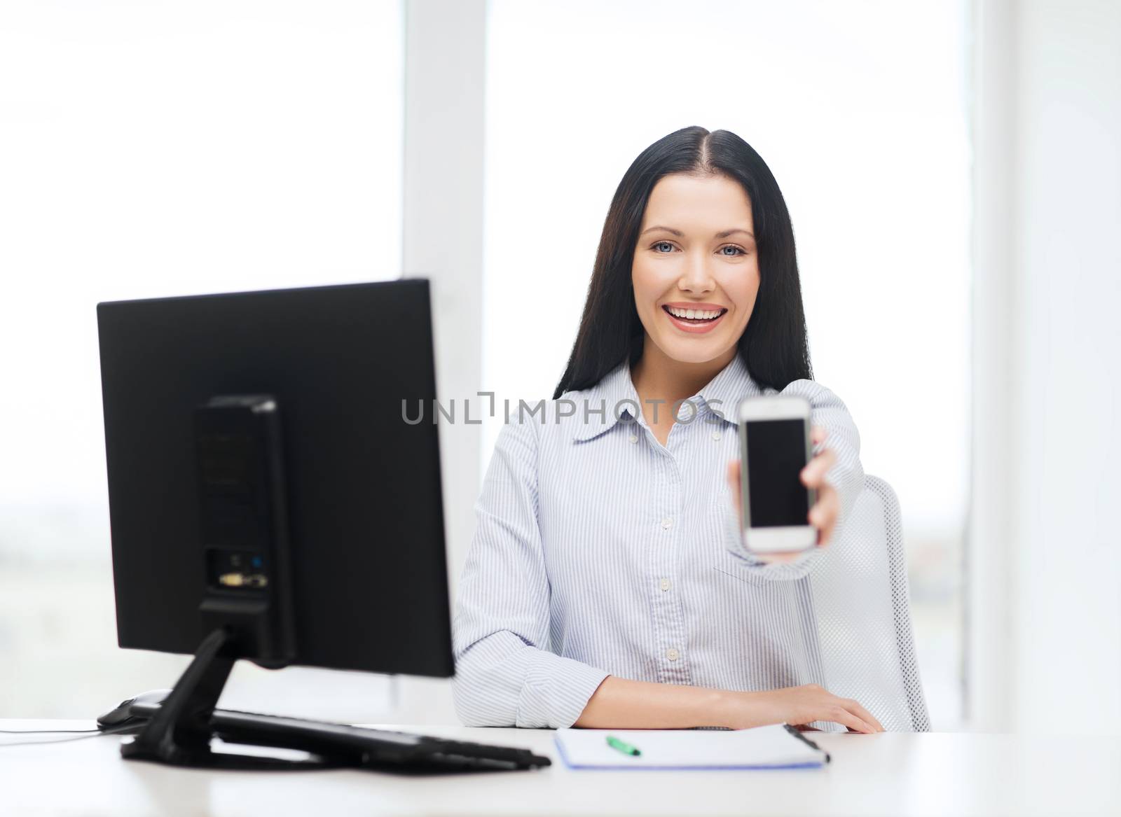 smiling businesswoman or student with smartphone by dolgachov