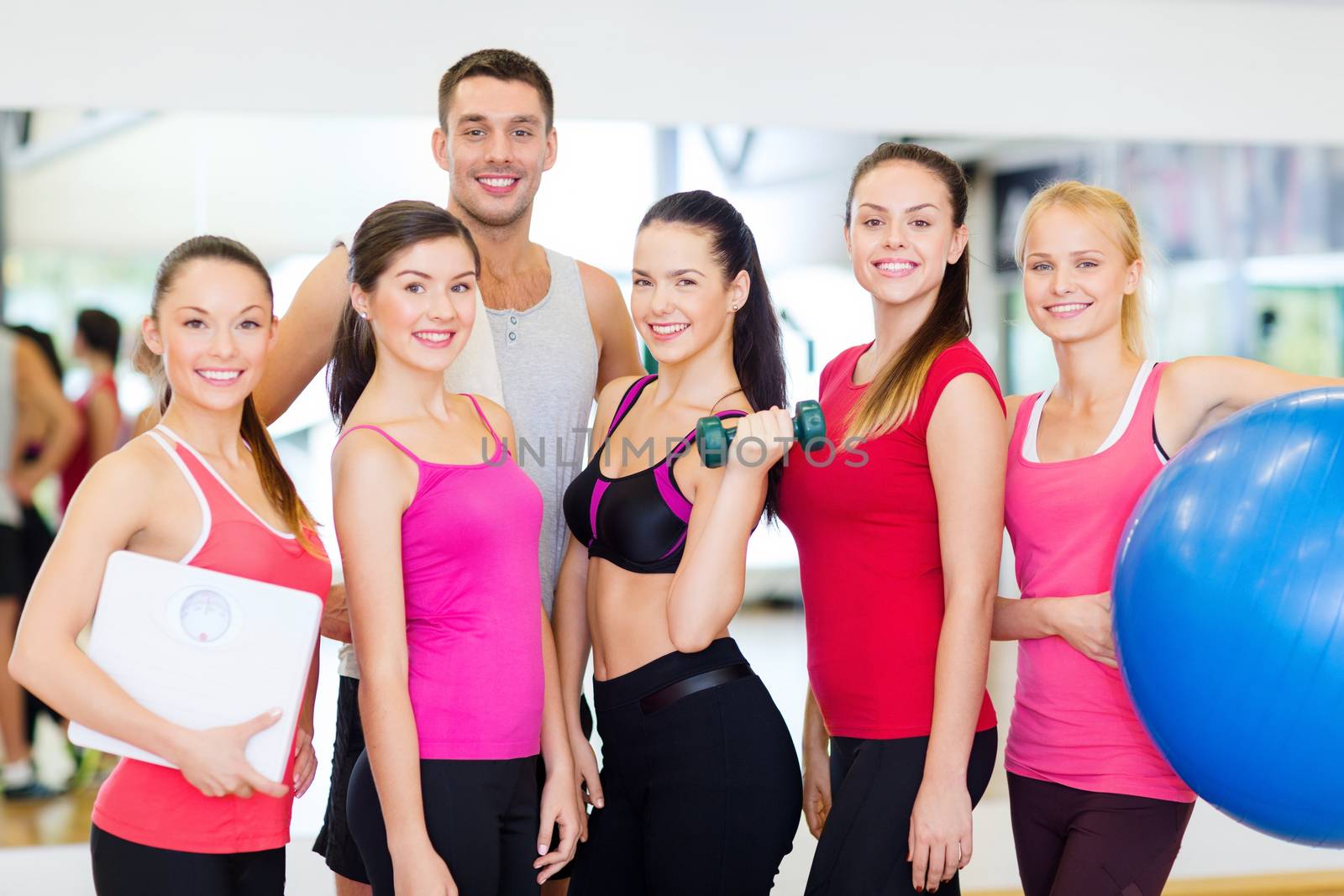 group of smiling people in the gym by dolgachov