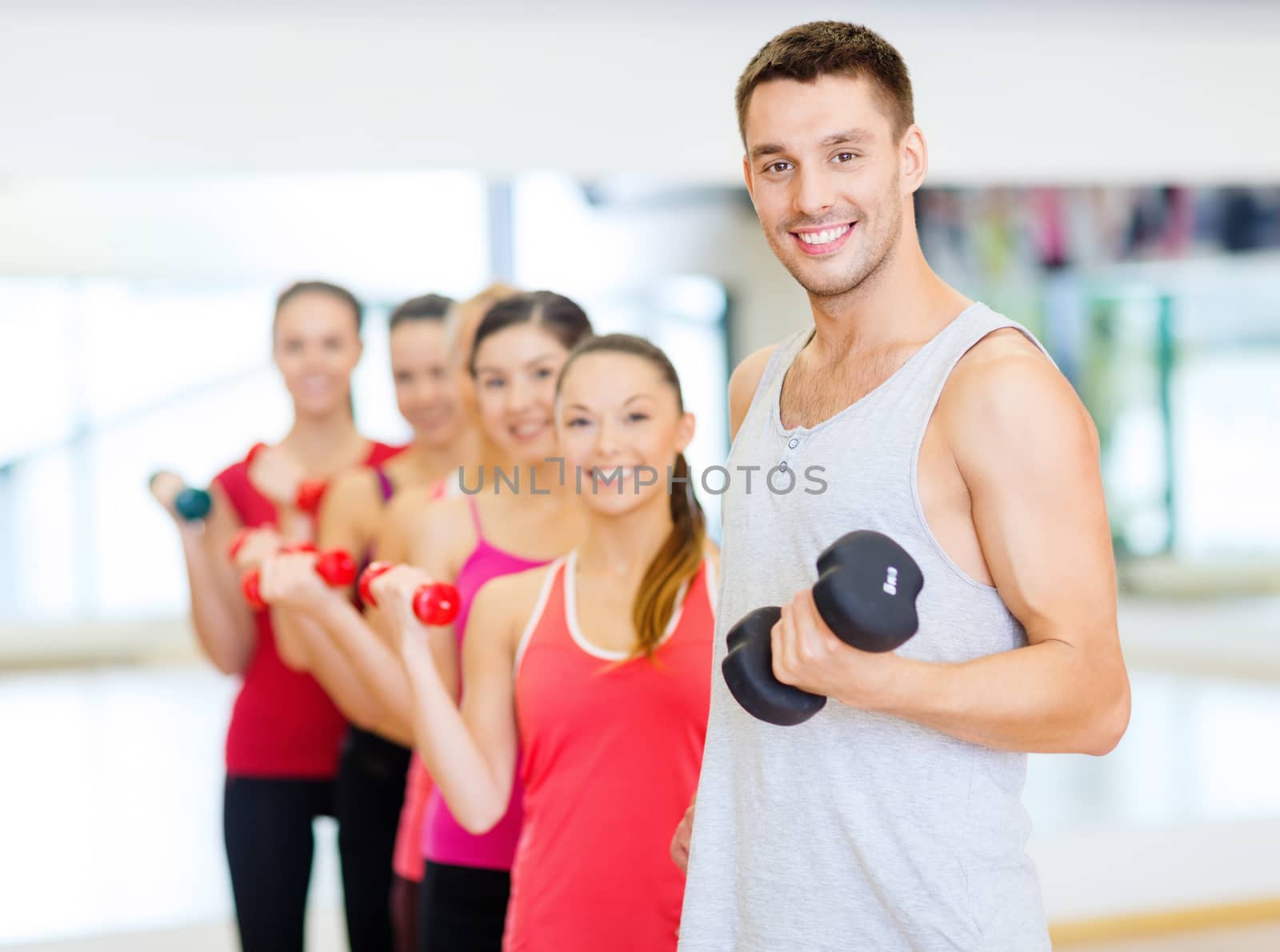 fitness, sport, training, gym and lifestyle concept - group of smiling people lifting dumbbells in the gym