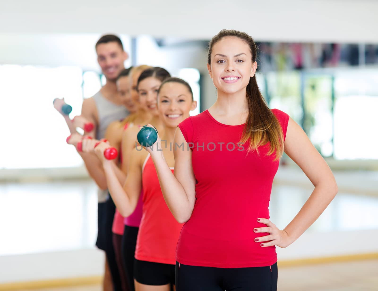 fitness, sport, training, gym and lifestyle concept - group of smiling people lifting dumbbells in the gym