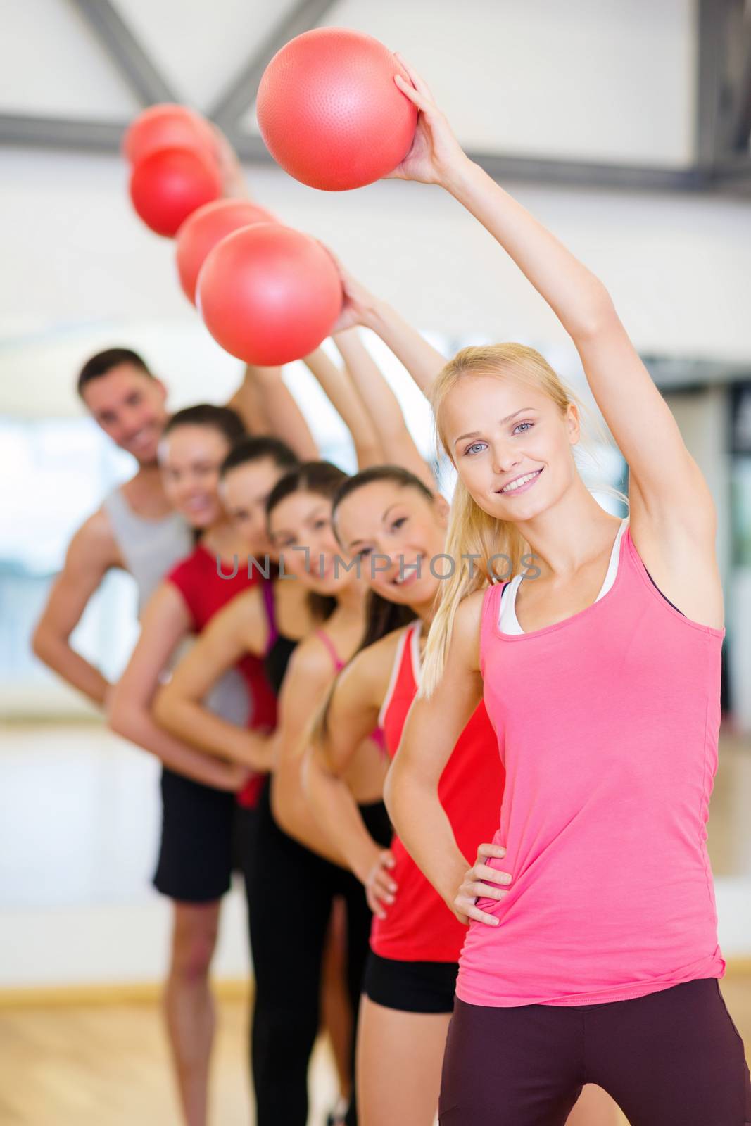 group of smiling people working out with ball by dolgachov