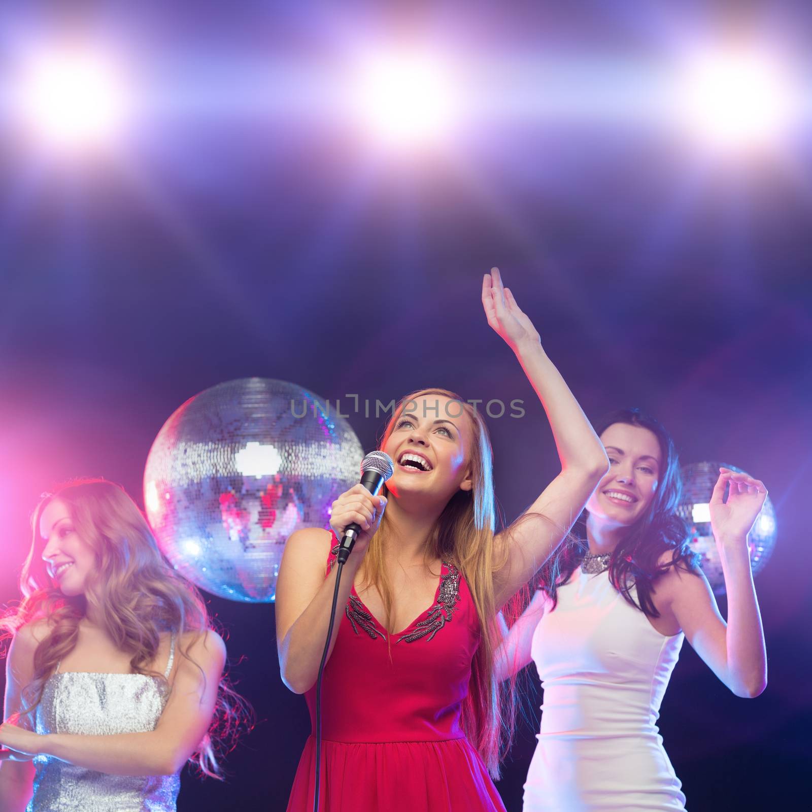 three smiling women dancing and singing karaoke by dolgachov