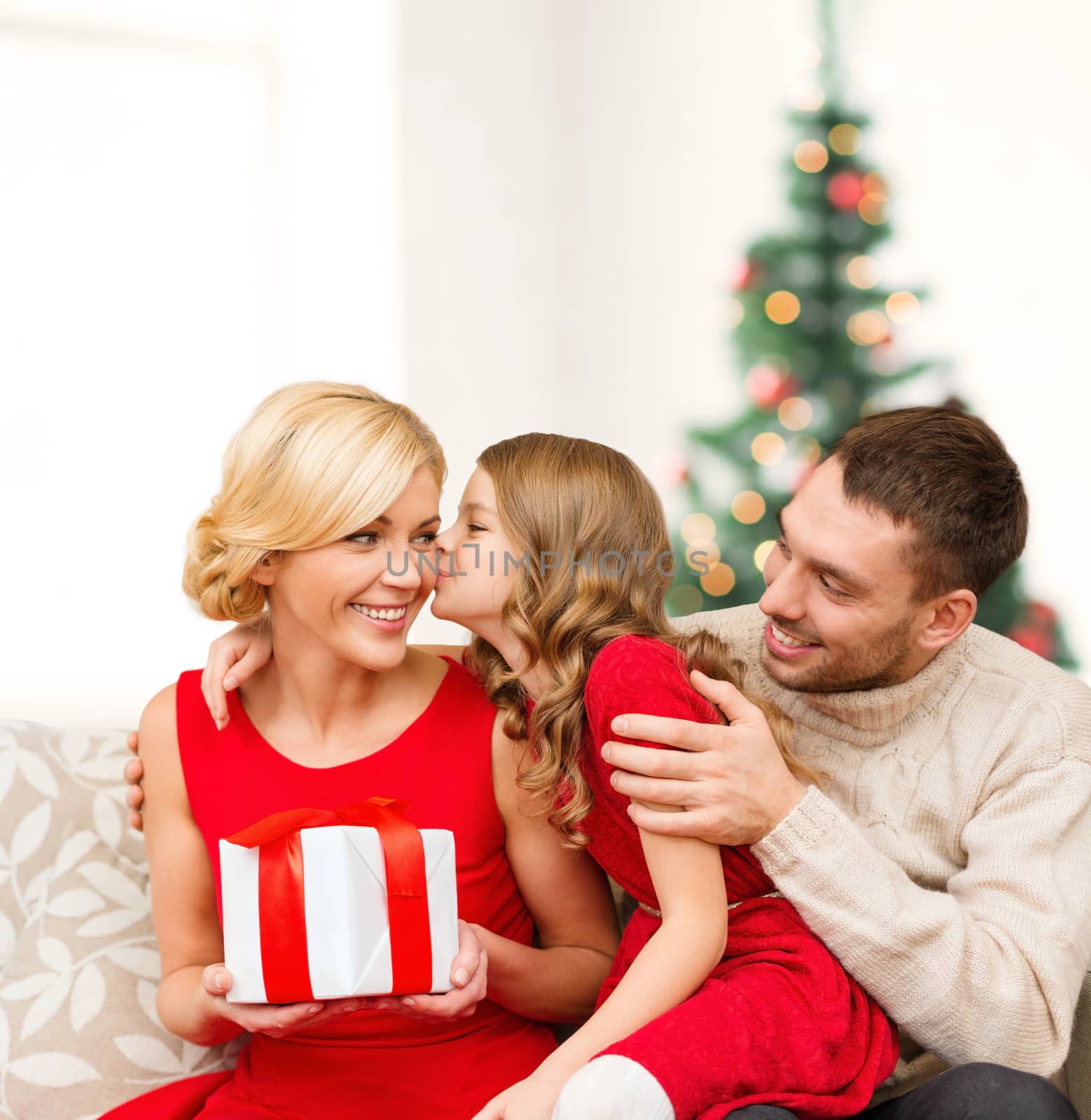 family, christmas, x-mas, winter, happiness and people concept - adorable child kisses her mother and gives present