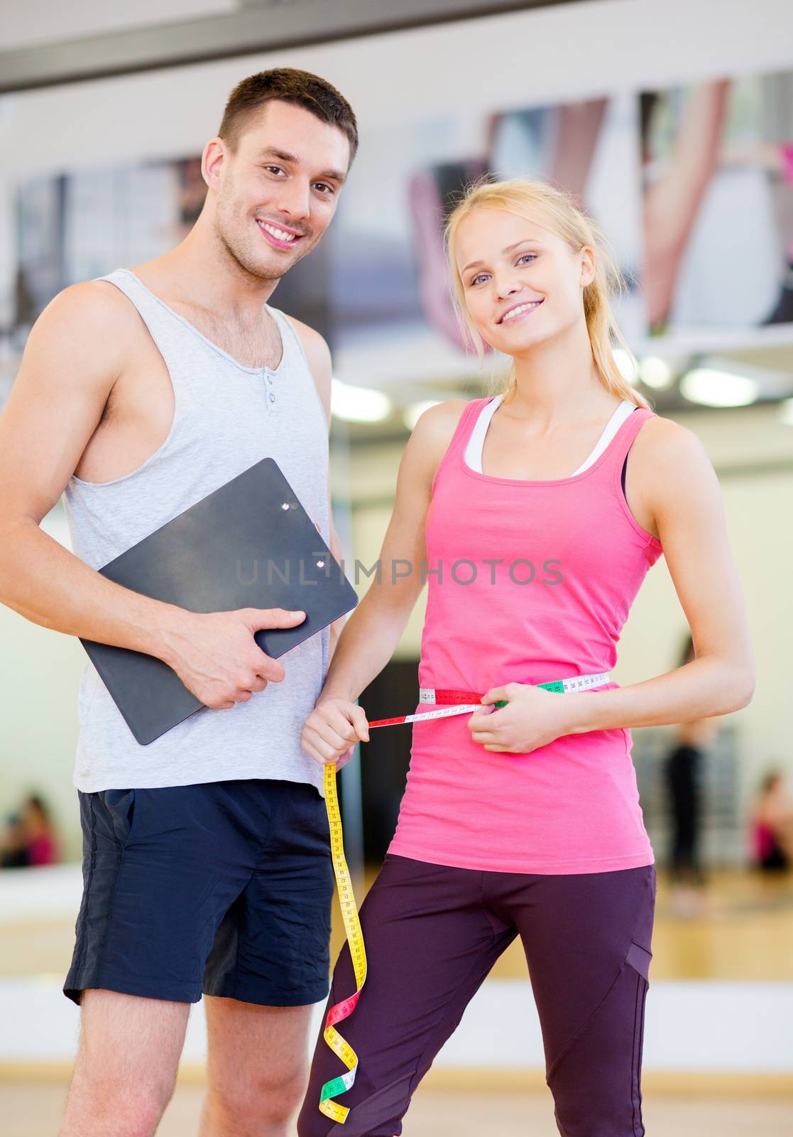 two smiling people with clipboard and measure tape by dolgachov