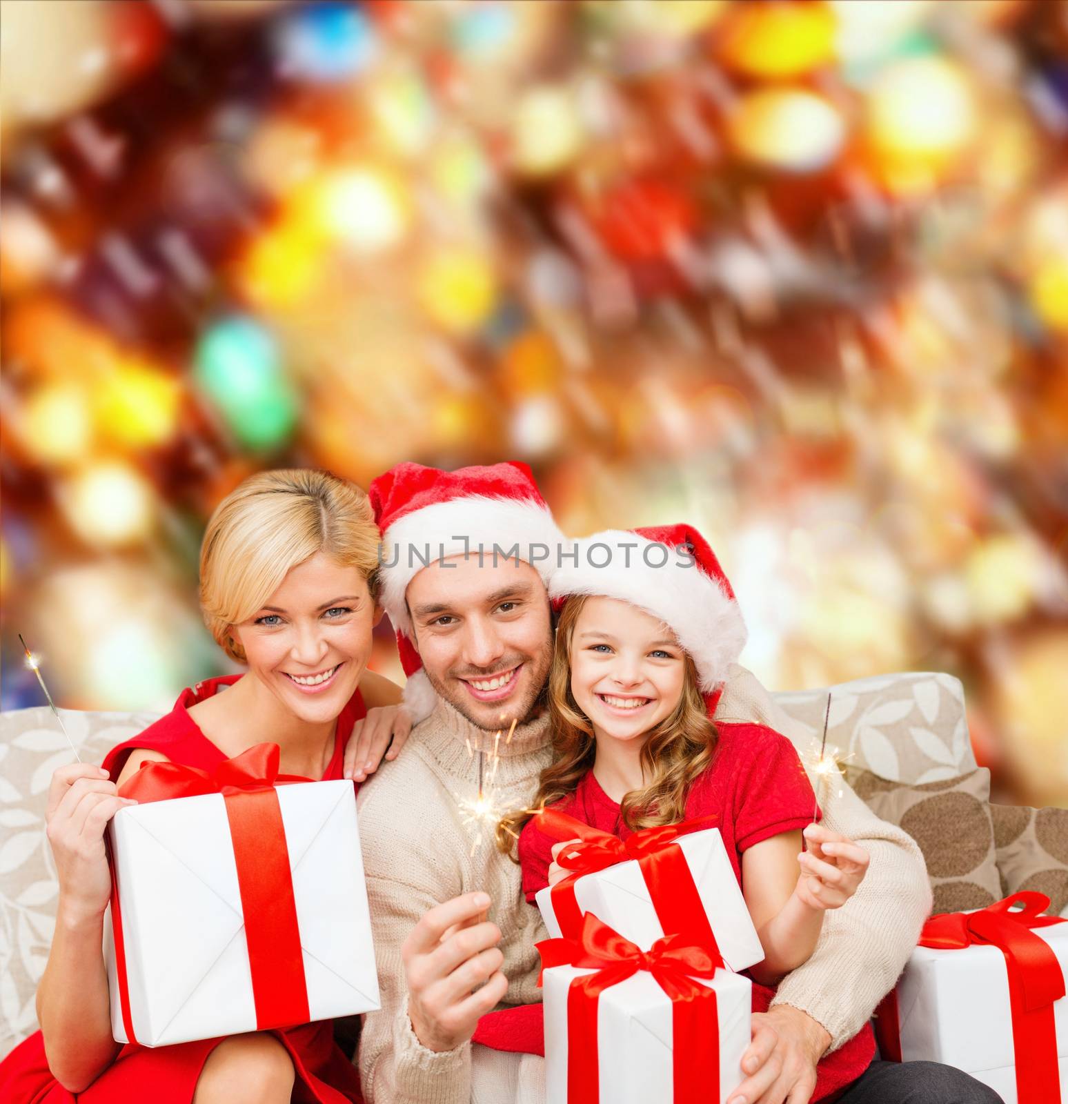 family, christmas, x-mas, winter, happiness and people concept - smiling family in santa helper hats with many gift boxes and bengal lights