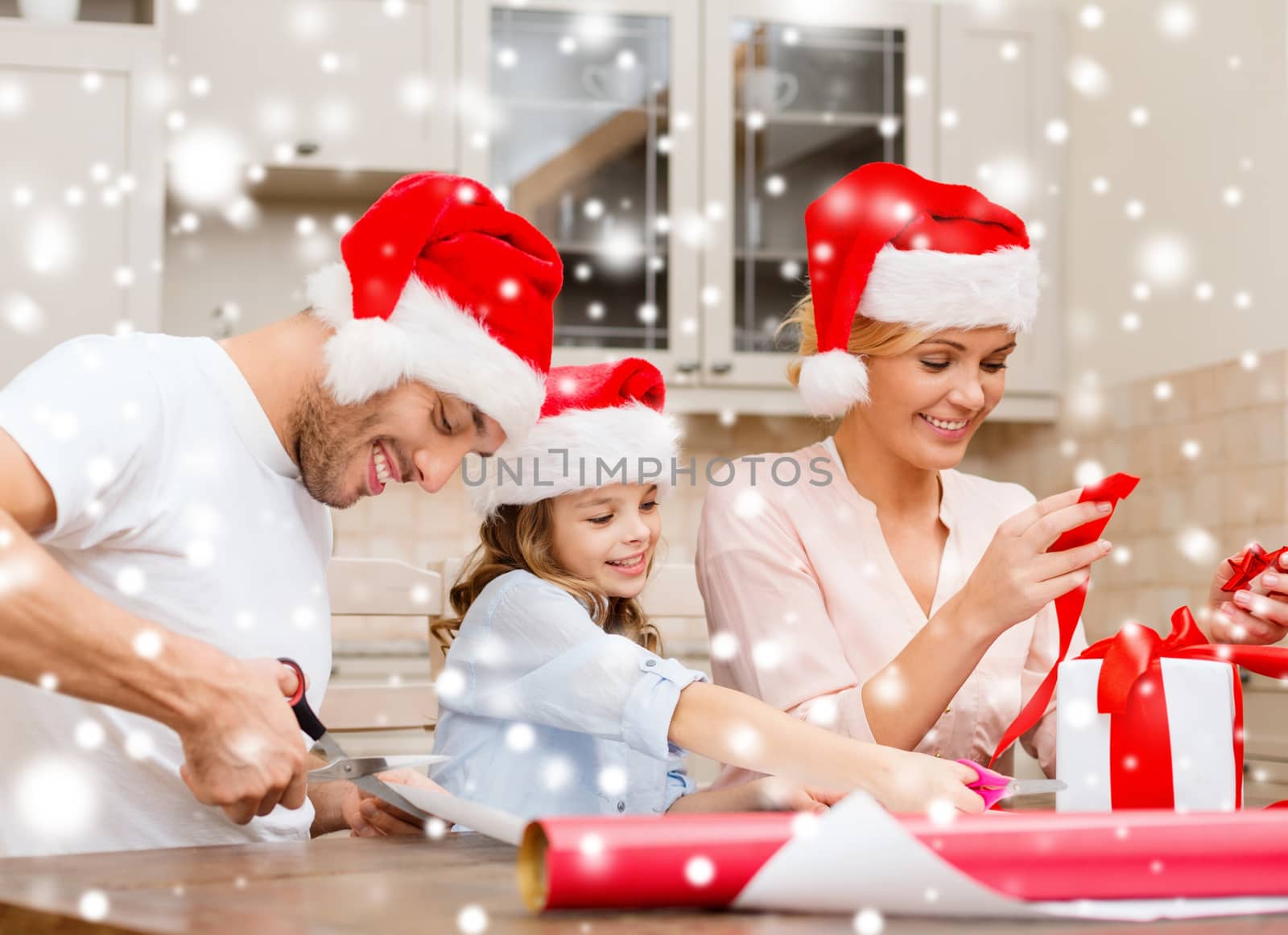 smiling family in santa helper hats with gift box by dolgachov