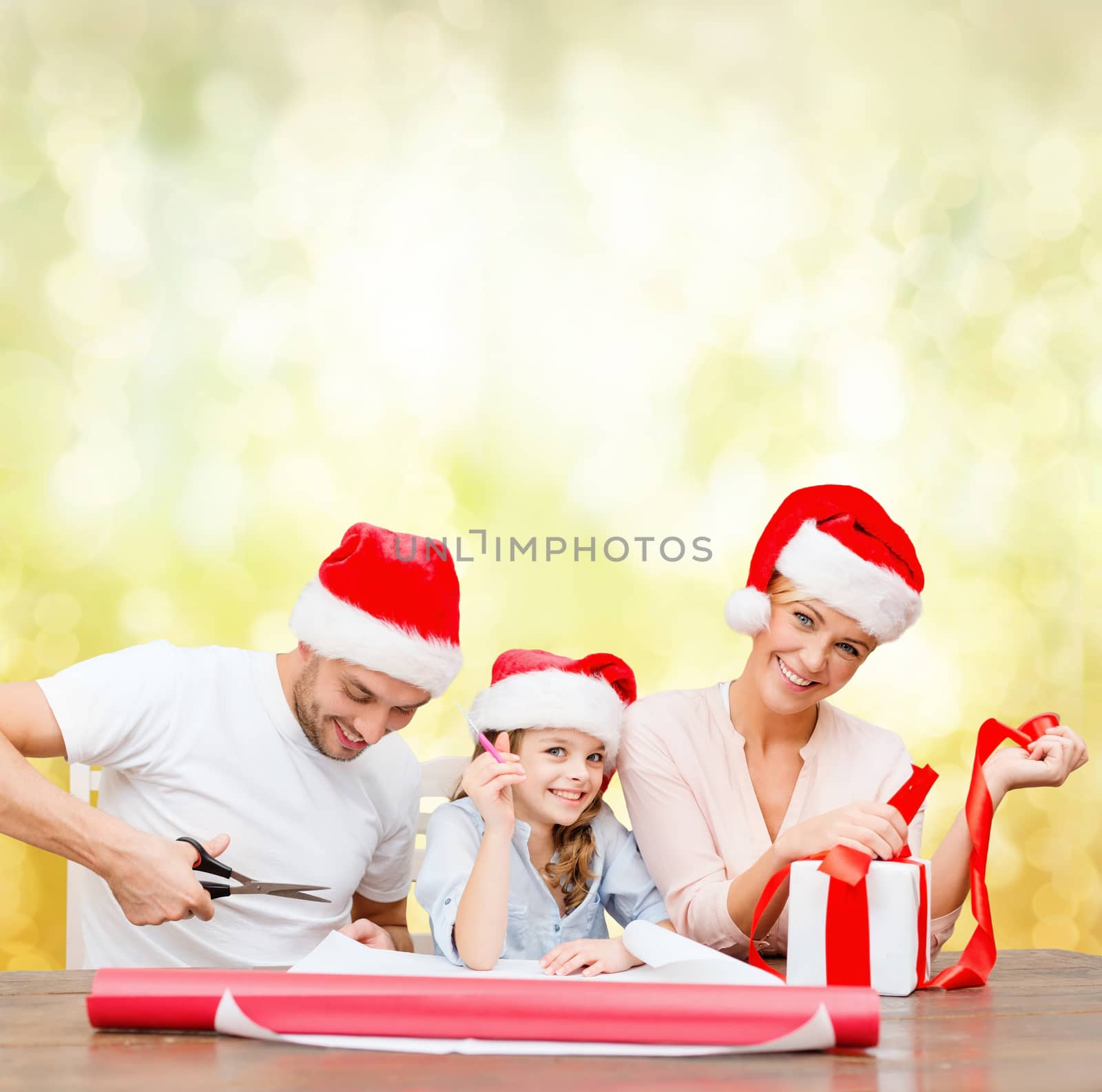 smiling family in santa helper hats with gift box by dolgachov