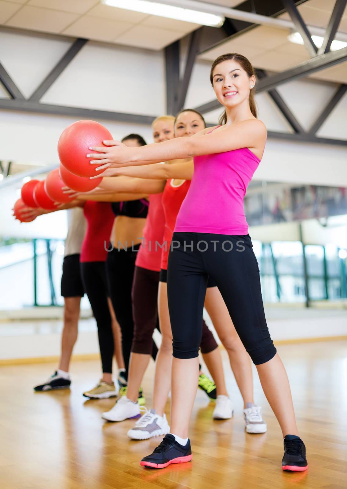 fitness, sport, training, gym and lifestyle concept - group of smiling people working out with stability balls in the gym