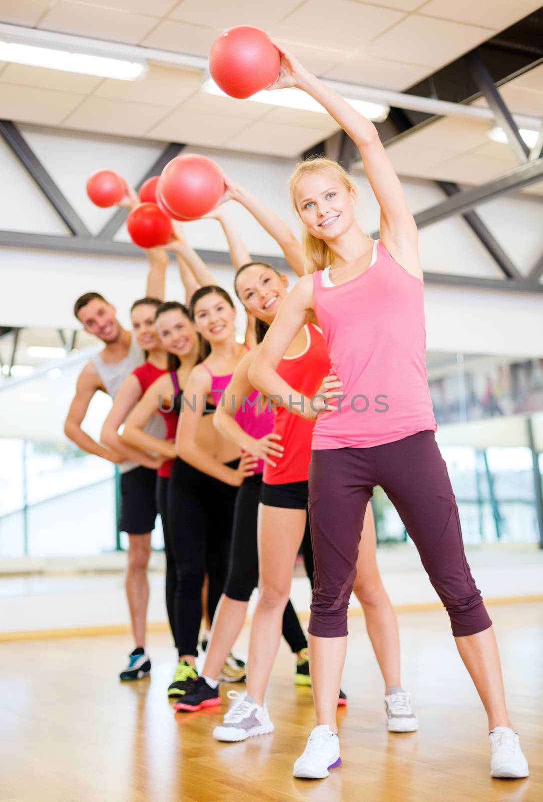 group of smiling people working out with ball by dolgachov