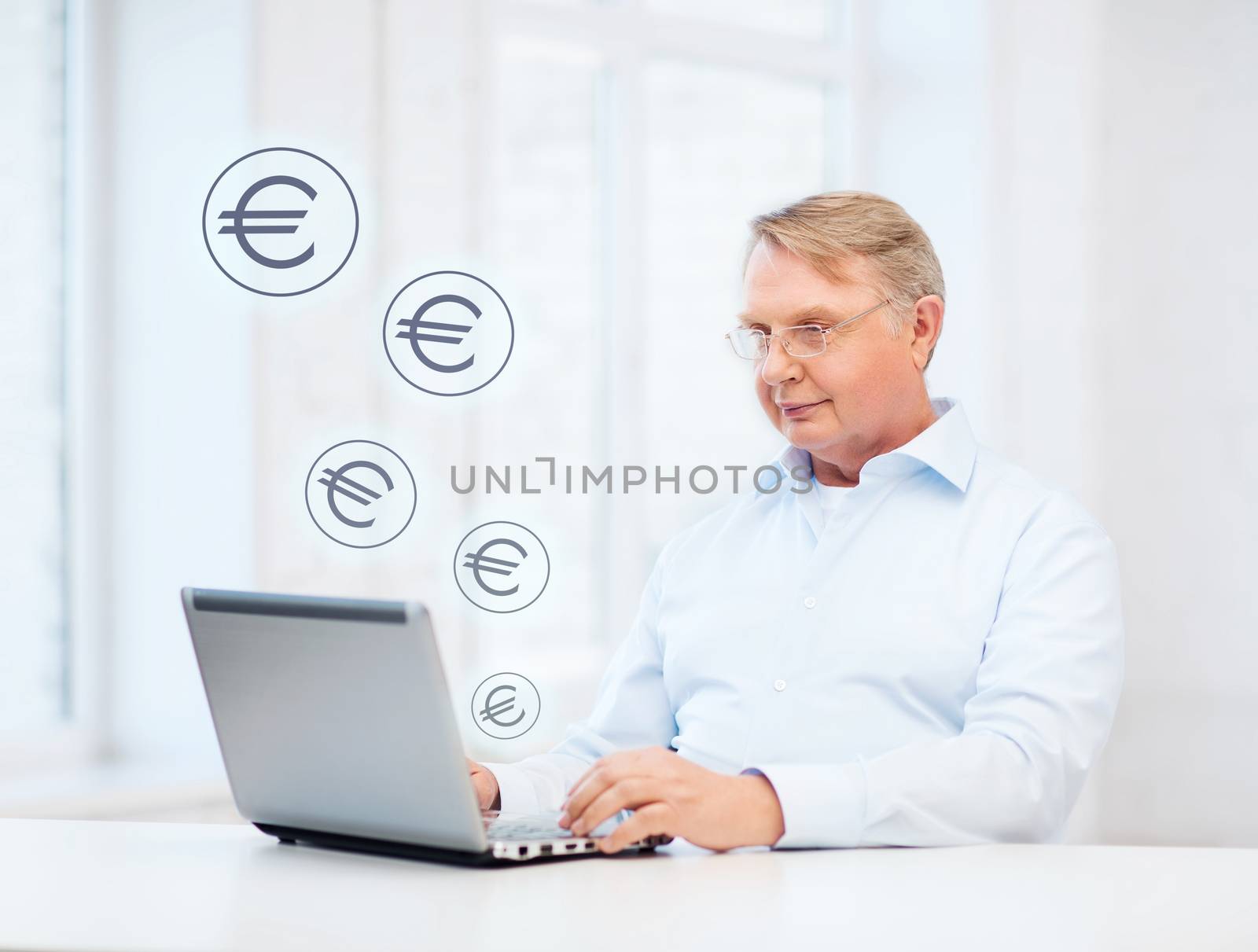 technology, oldness and lifestyle concept - old man in eyeglasses working with laptop computer at home