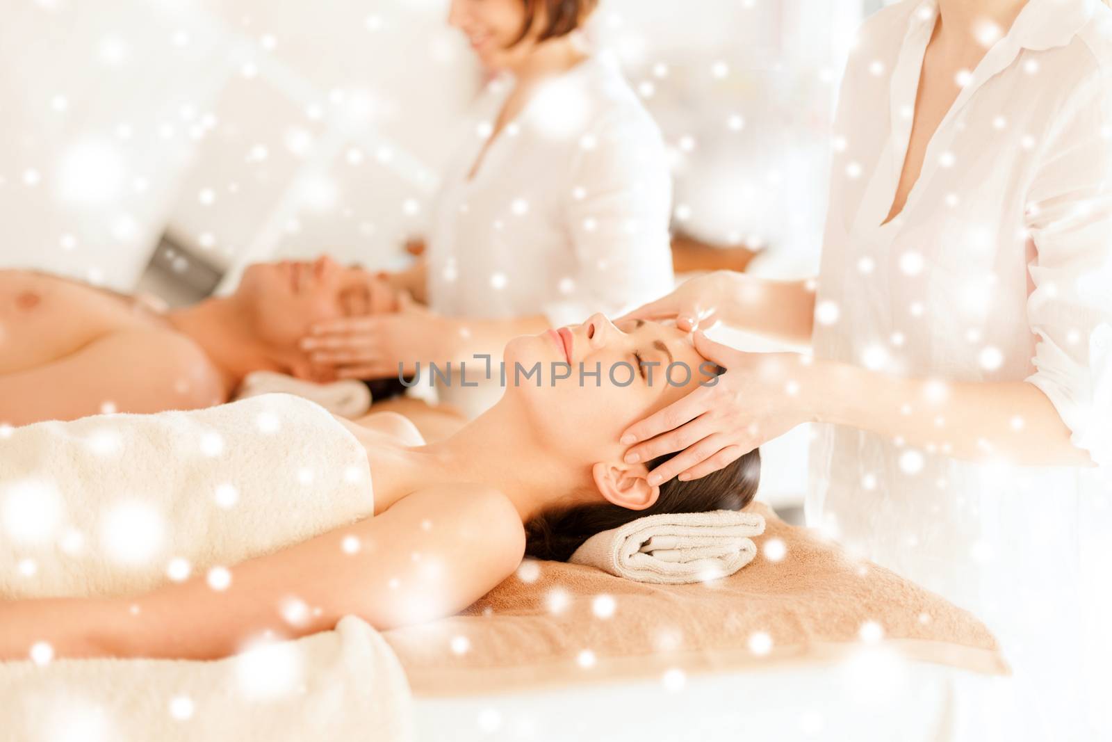 couple getting facial massage in spa by dolgachov