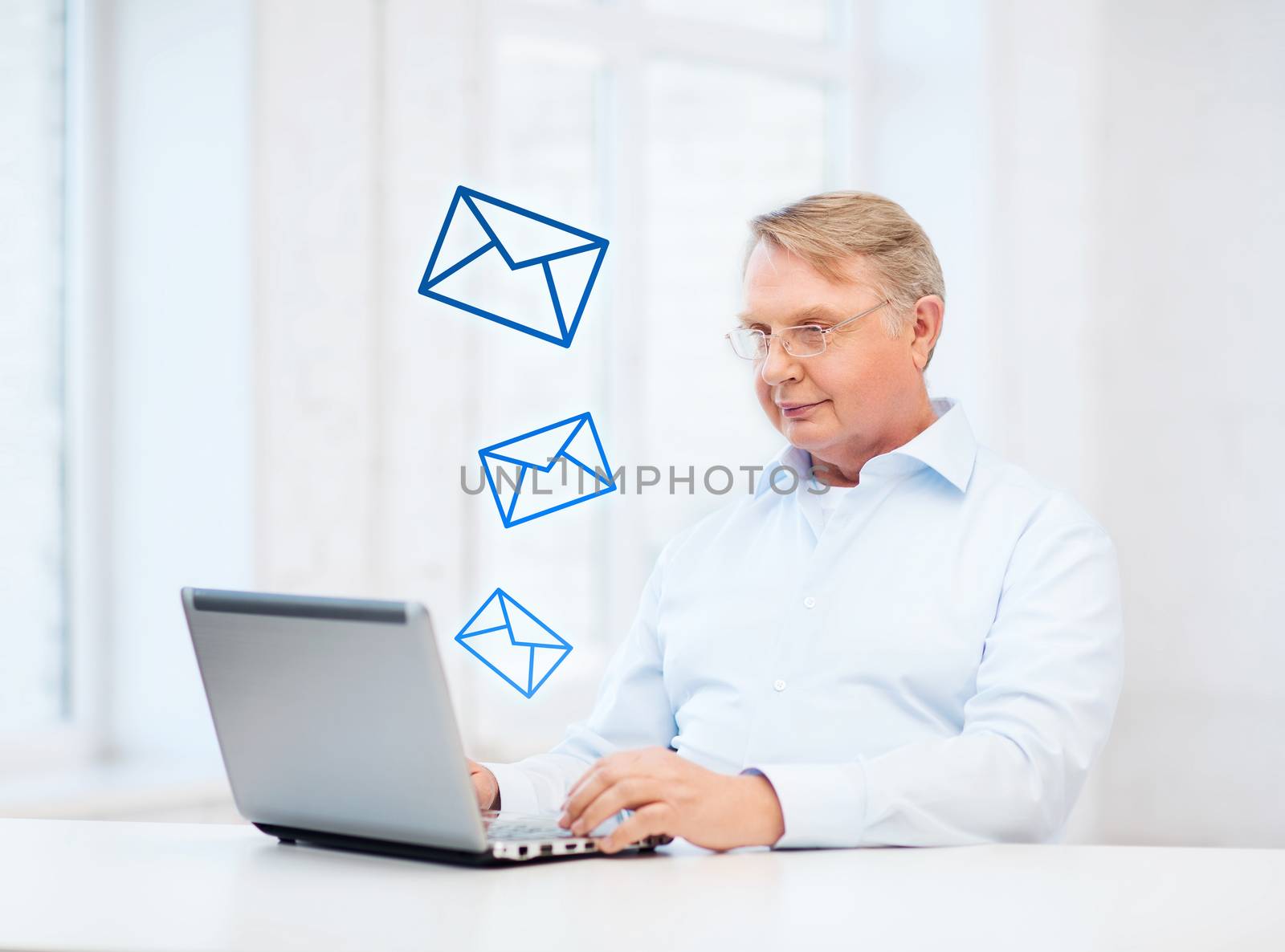 technology, oldness and lifestyle concept - old man in eyeglasses working with laptop computer at home