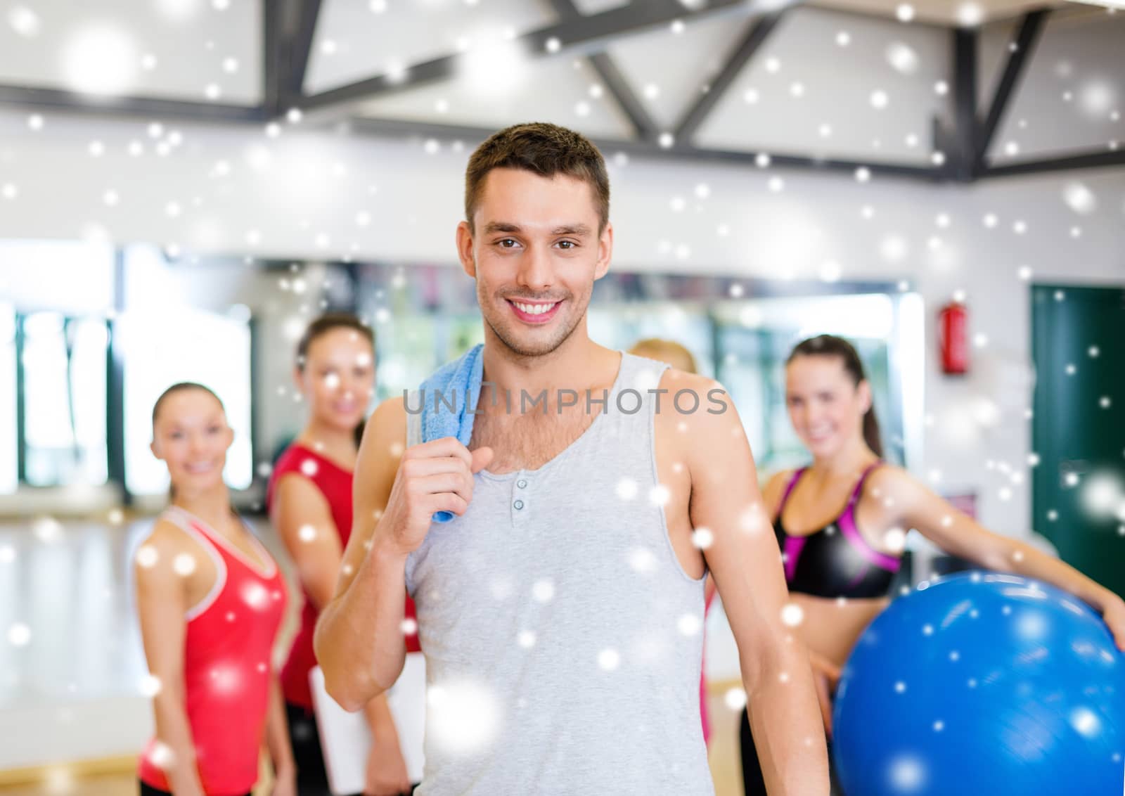 fitness, sport, training, gym and lifestyle concept - smiling man standing in front of the group of people in gym