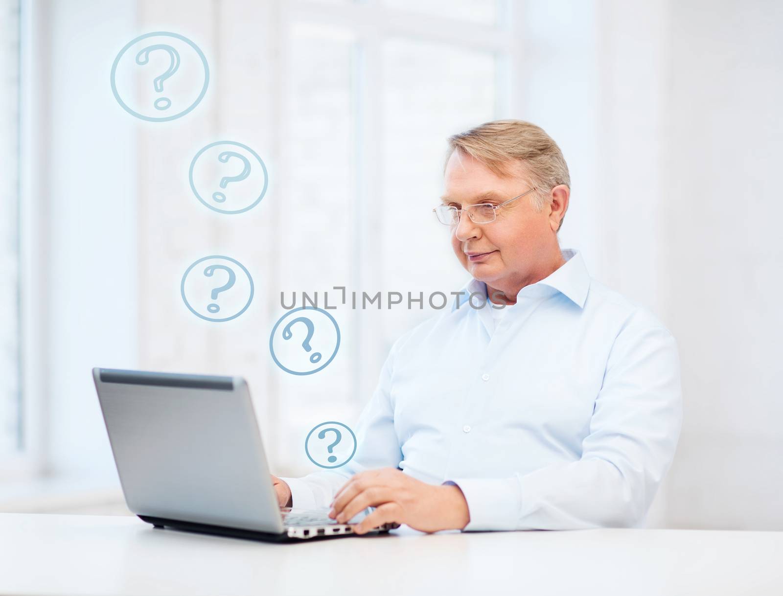 technology, oldness and lifestyle concept - old man in eyeglasses working with laptop computer at home
